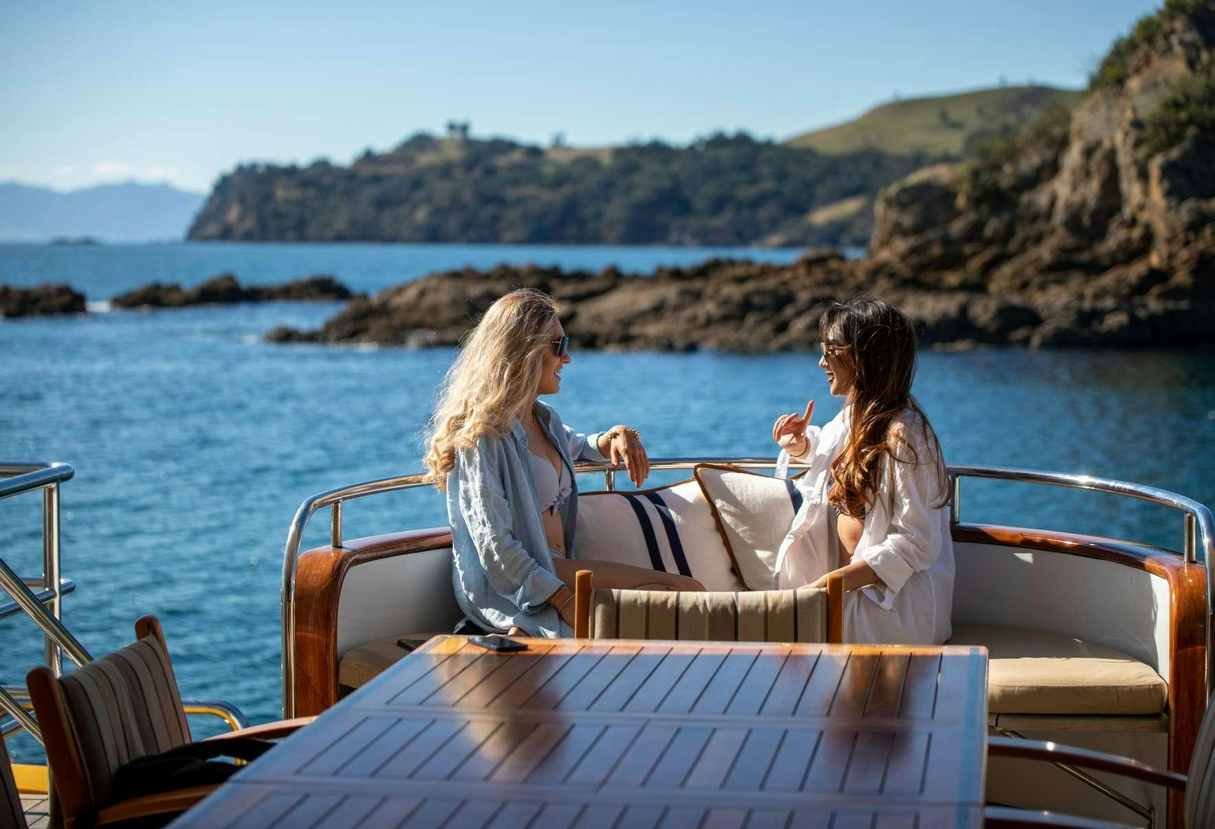 a couple of women sitting on a boat aboard PACIFIC MERMAID Yacht for Charter