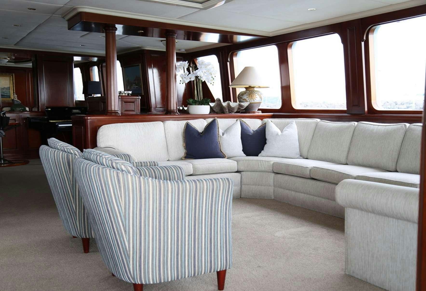 a couch and a chair in a room aboard PACIFIC MERMAID Yacht for Charter