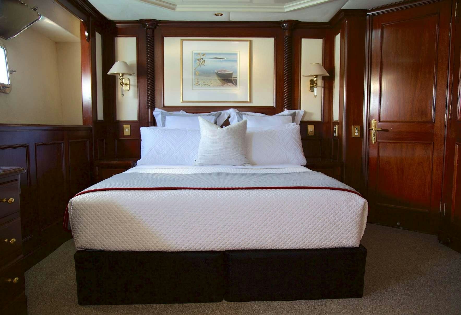 a bed with white sheets aboard PACIFIC MERMAID Yacht for Charter