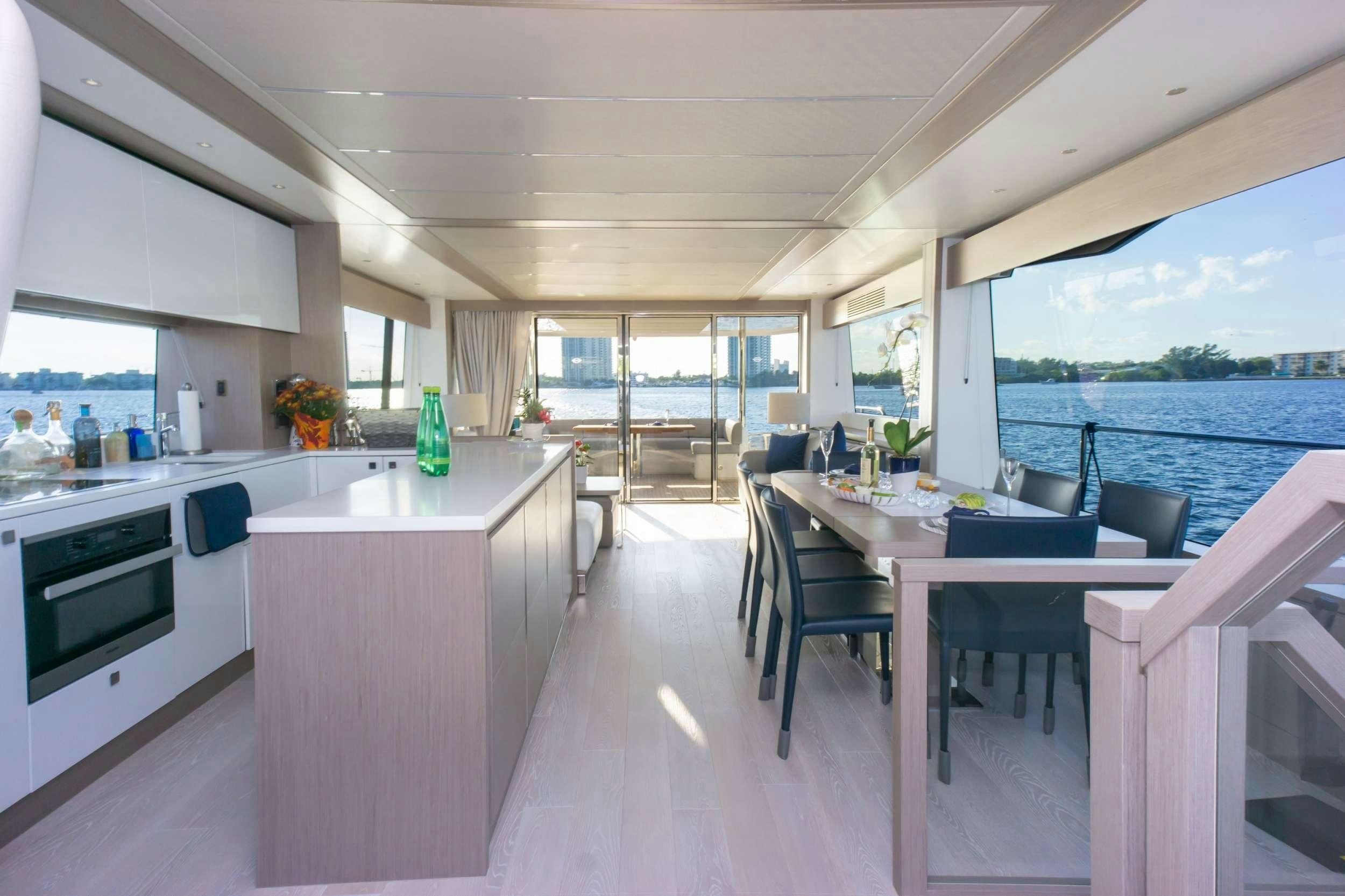 a kitchen with a table and chairs aboard MILAMO Yacht for Charter
