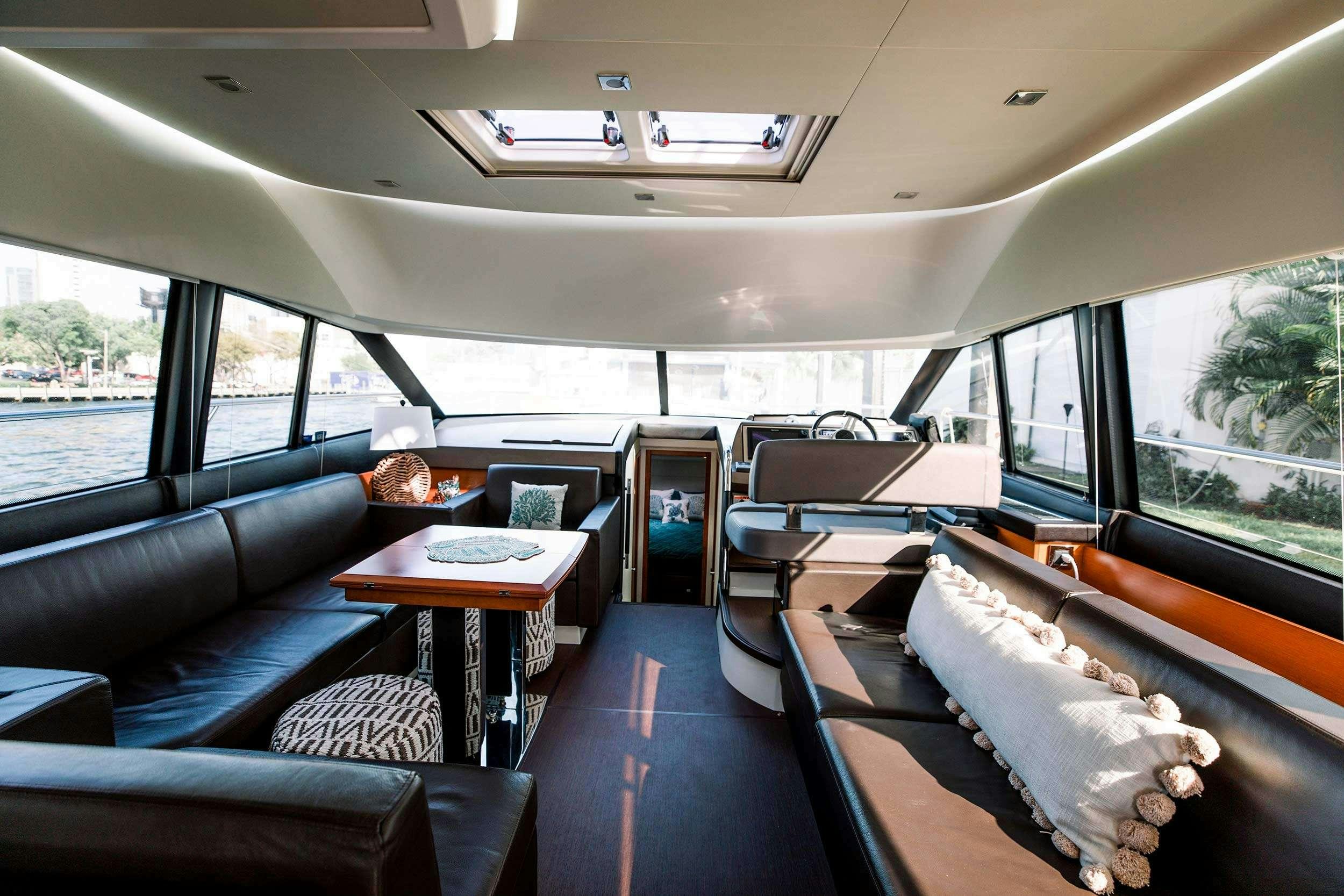 inside of a vehicle with a table and chairs and a couch aboard Patinga, Fort Lauderdale Yacht for Charter