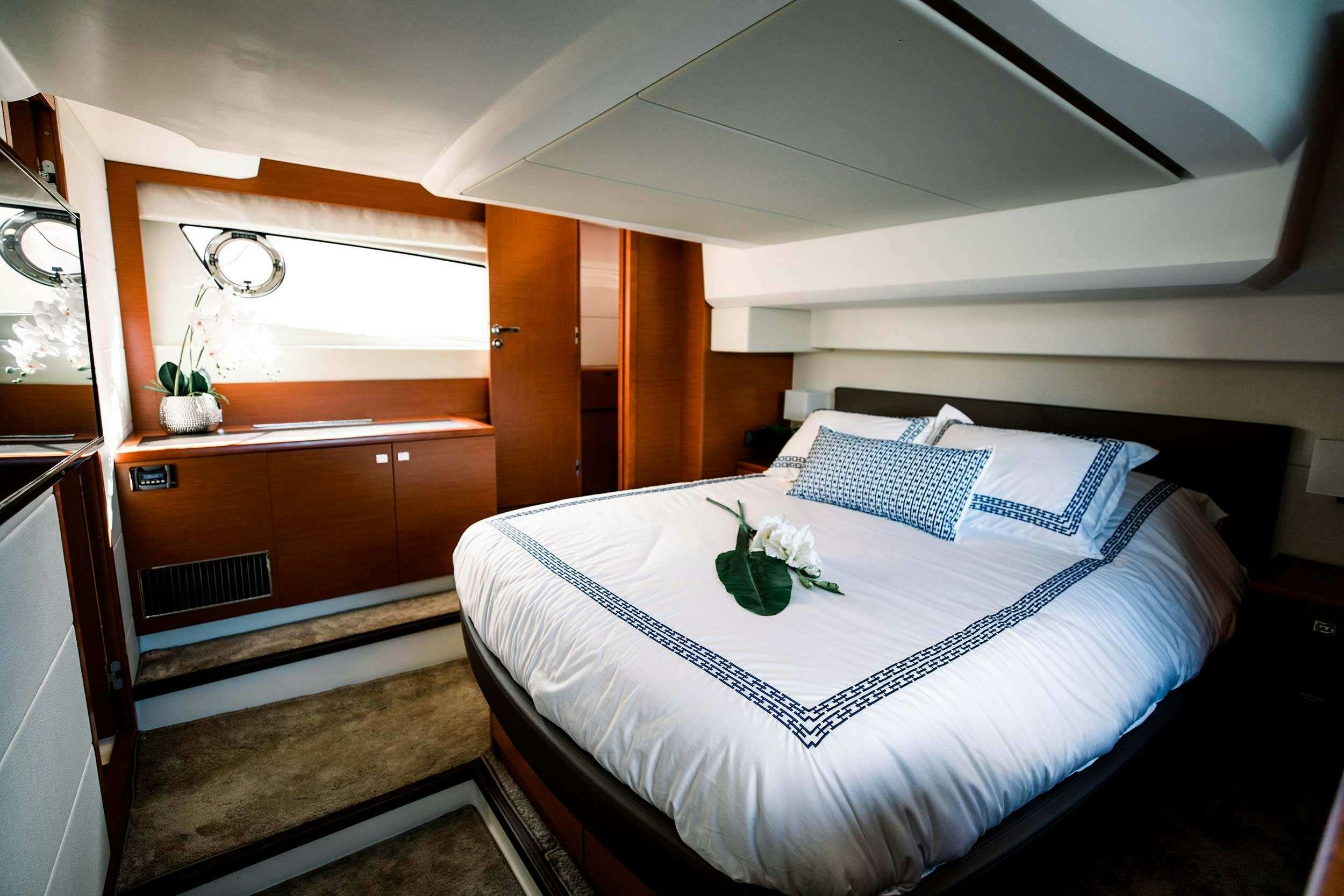 a bed with a flower on the bed aboard Patinga, Fort Lauderdale Yacht for Charter