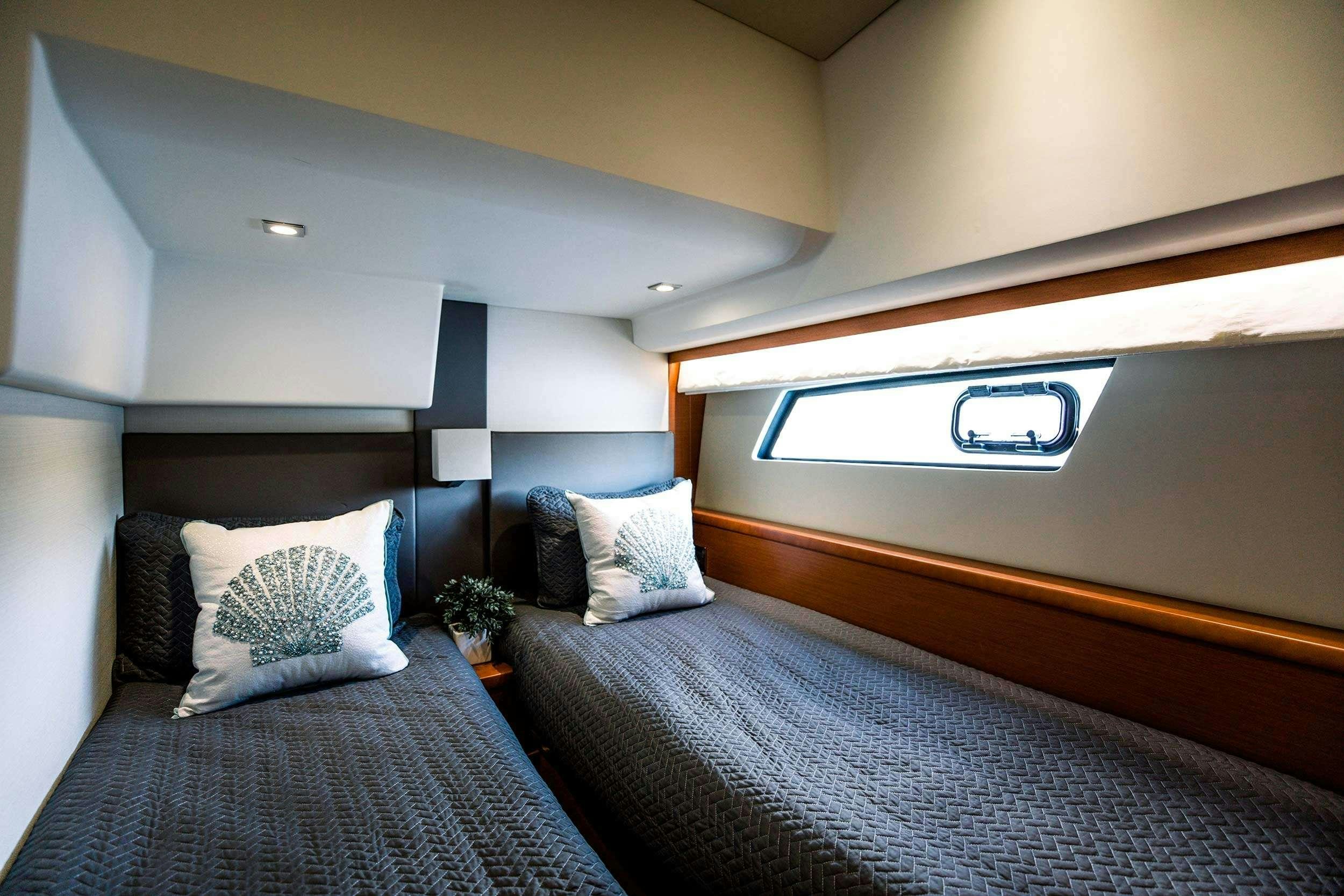 a bed with a blue and white bed spread and a black pillow aboard Patinga, Fort Lauderdale Yacht for Charter