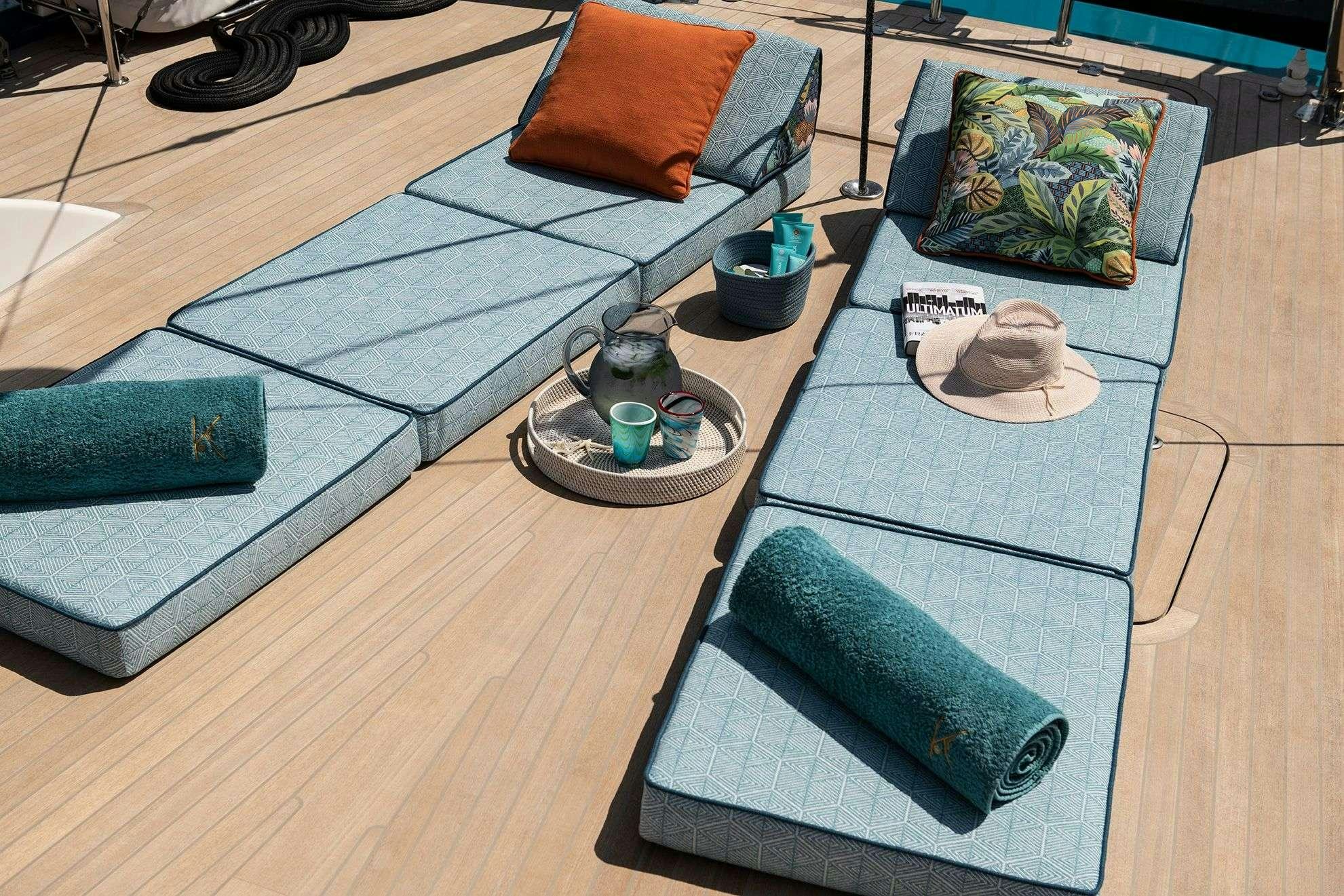 a couch with pillows and a rug aboard KARIBU Yacht for Charter