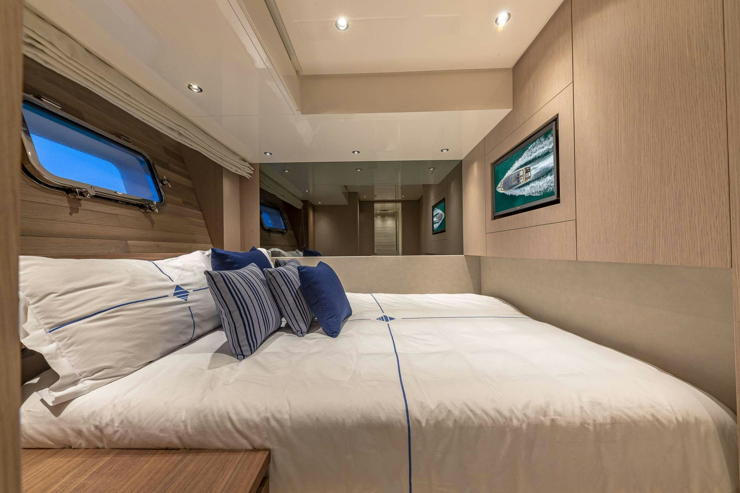 a room with a bed and a television aboard NO MATTER WHAT Yacht for Charter