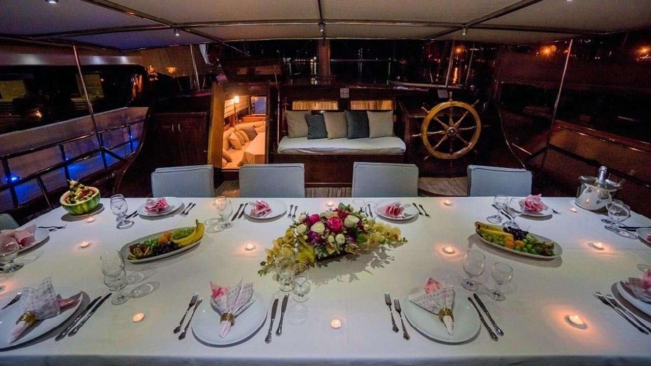a table set with plates and flowers aboard AMETIST A Yacht for Charter
