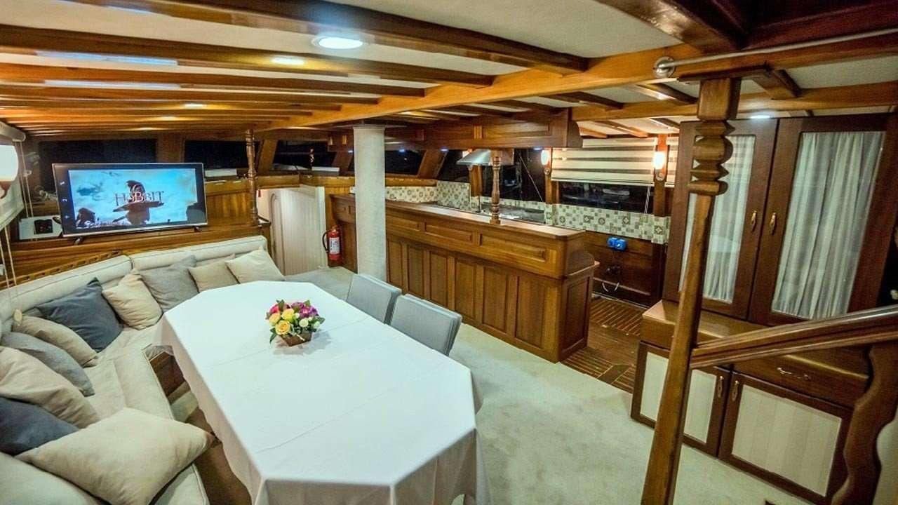 a room with a table and couch aboard AMETIST A Yacht for Charter
