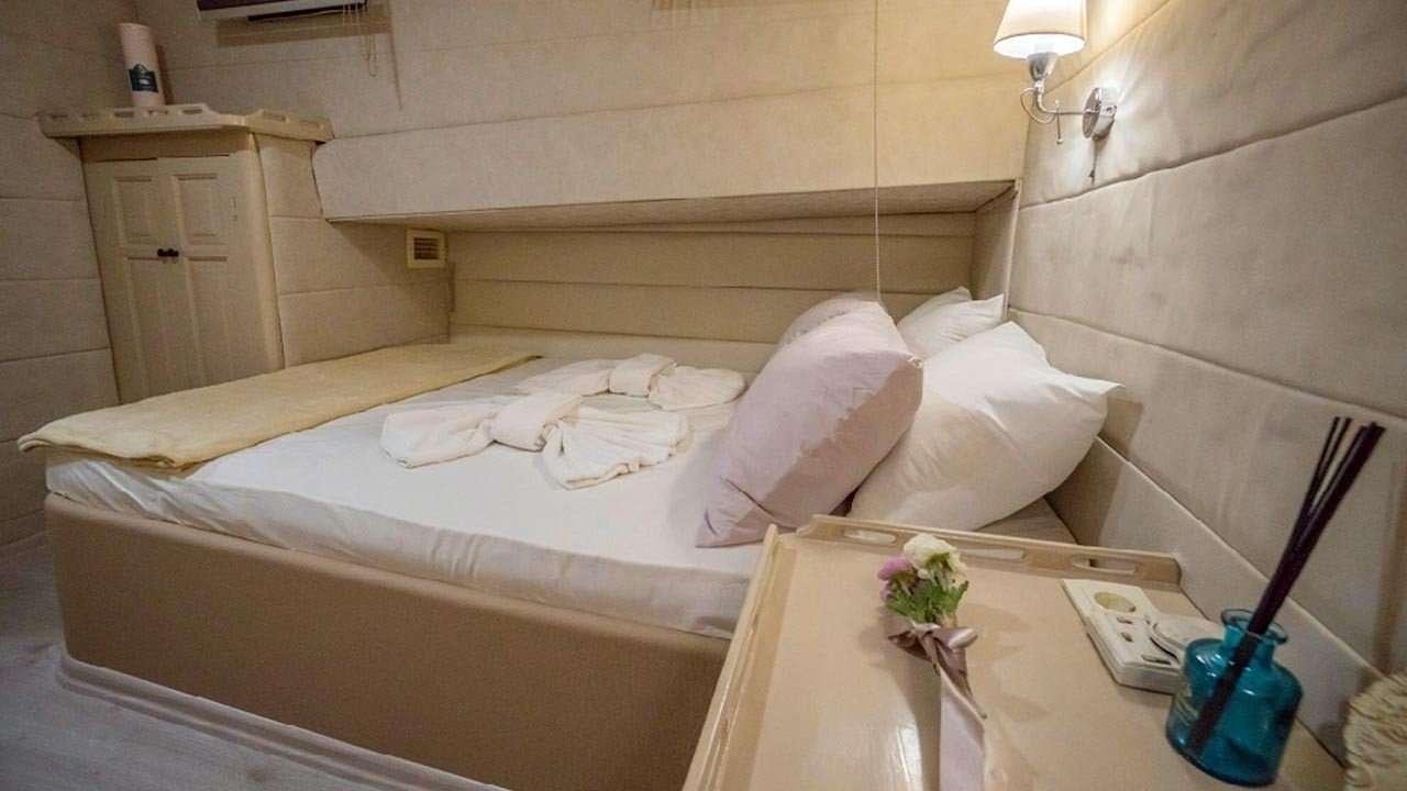 a bed with white sheets and pillows aboard AMETIST A Yacht for Charter