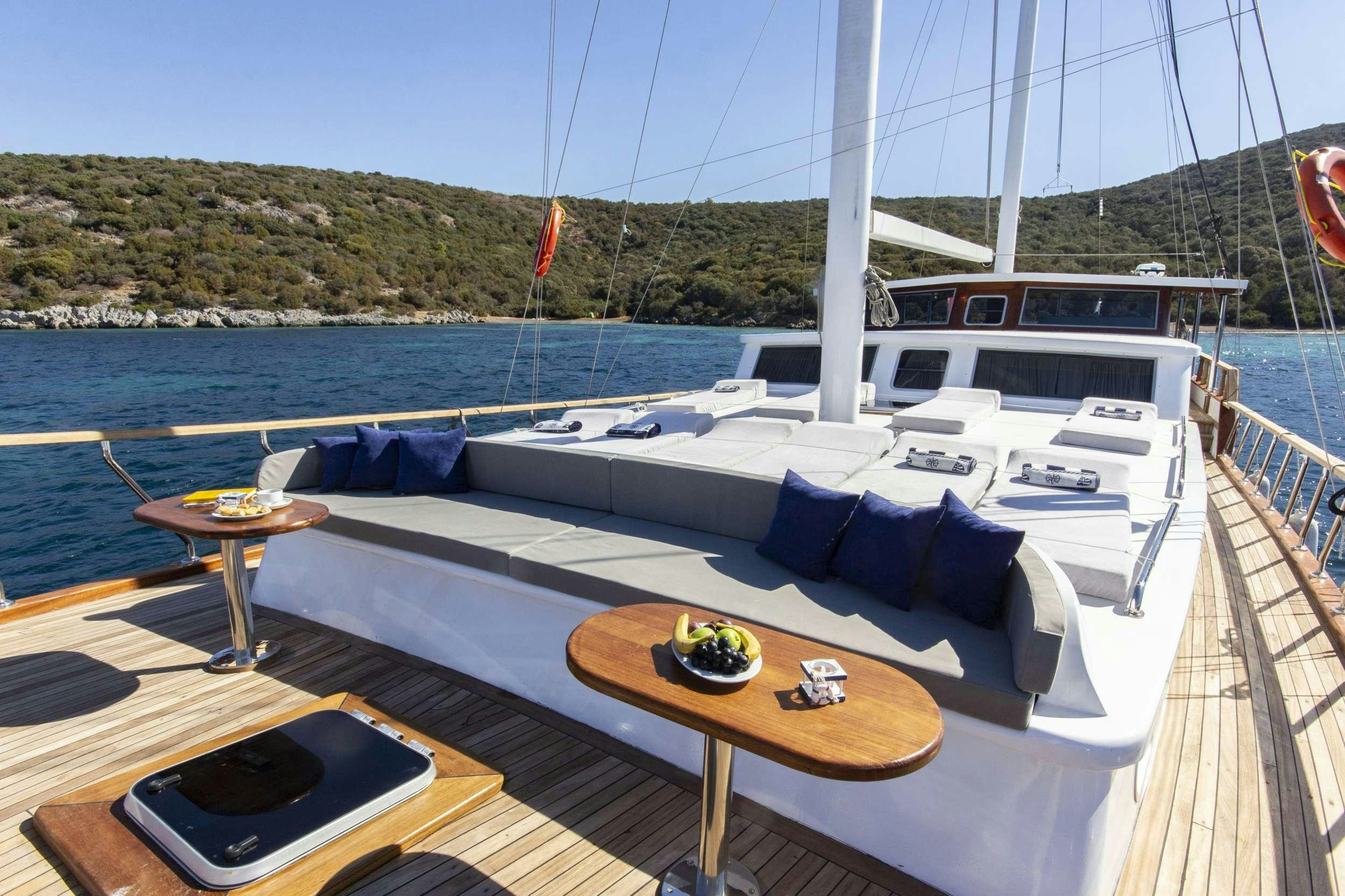 a deck with a table and chairs on it aboard MARE D ELFIDA Yacht for Charter