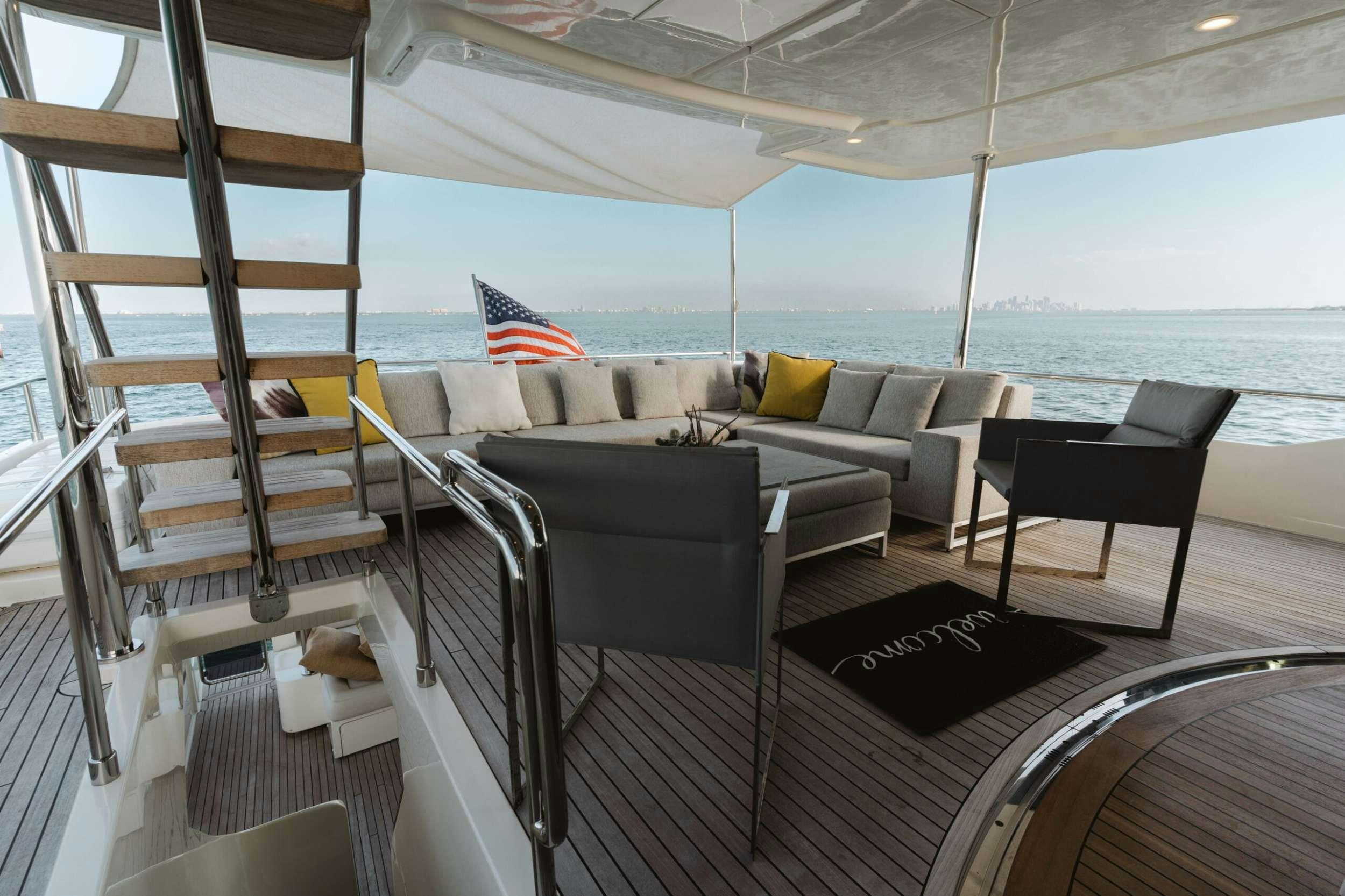 a deck with a couch and chairs aboard BONUS ROUND Yacht for Charter