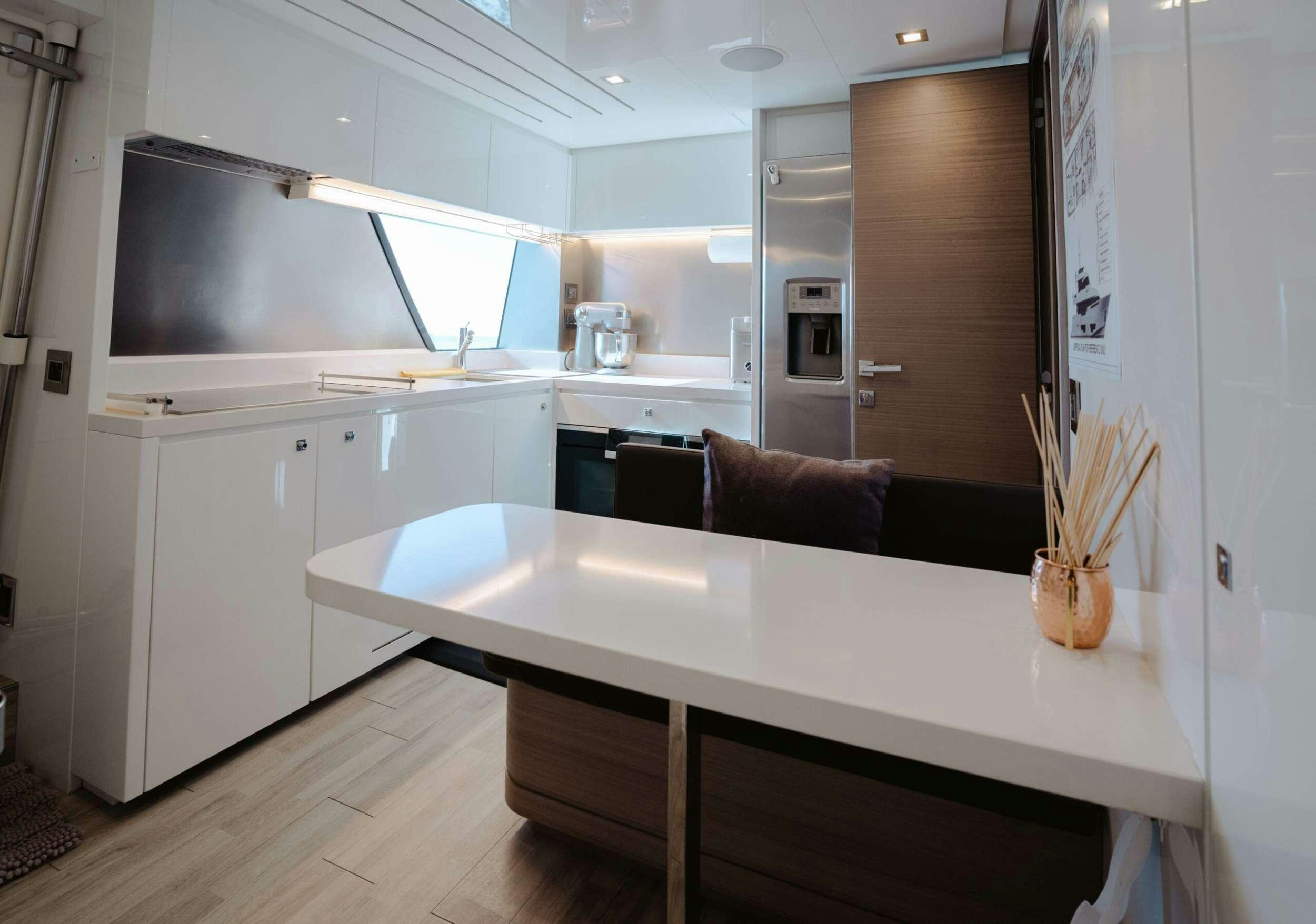 a kitchen with a table and chairs aboard BONUS ROUND Yacht for Charter