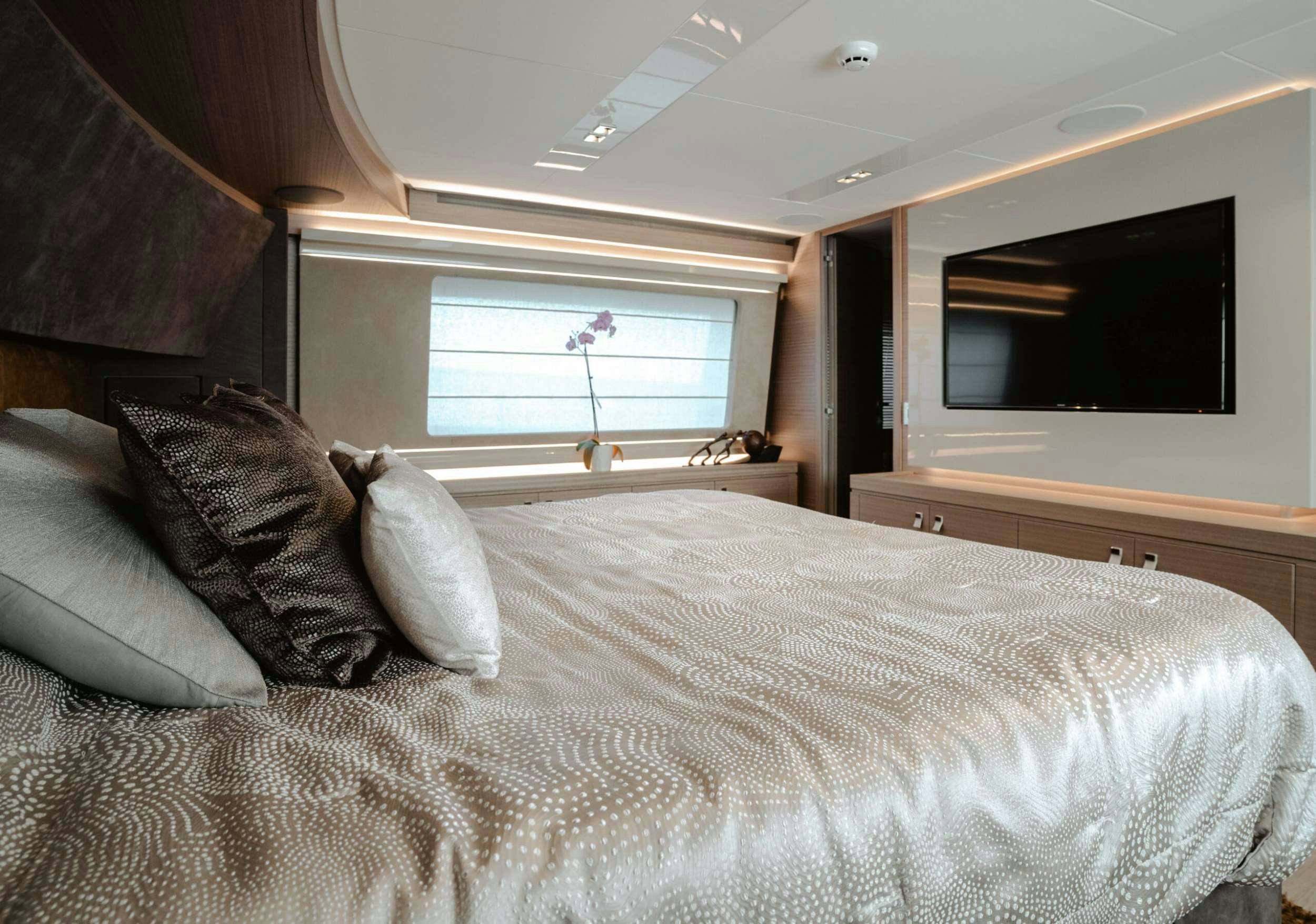 a bed with pillows and a television aboard BONUS ROUND Yacht for Charter