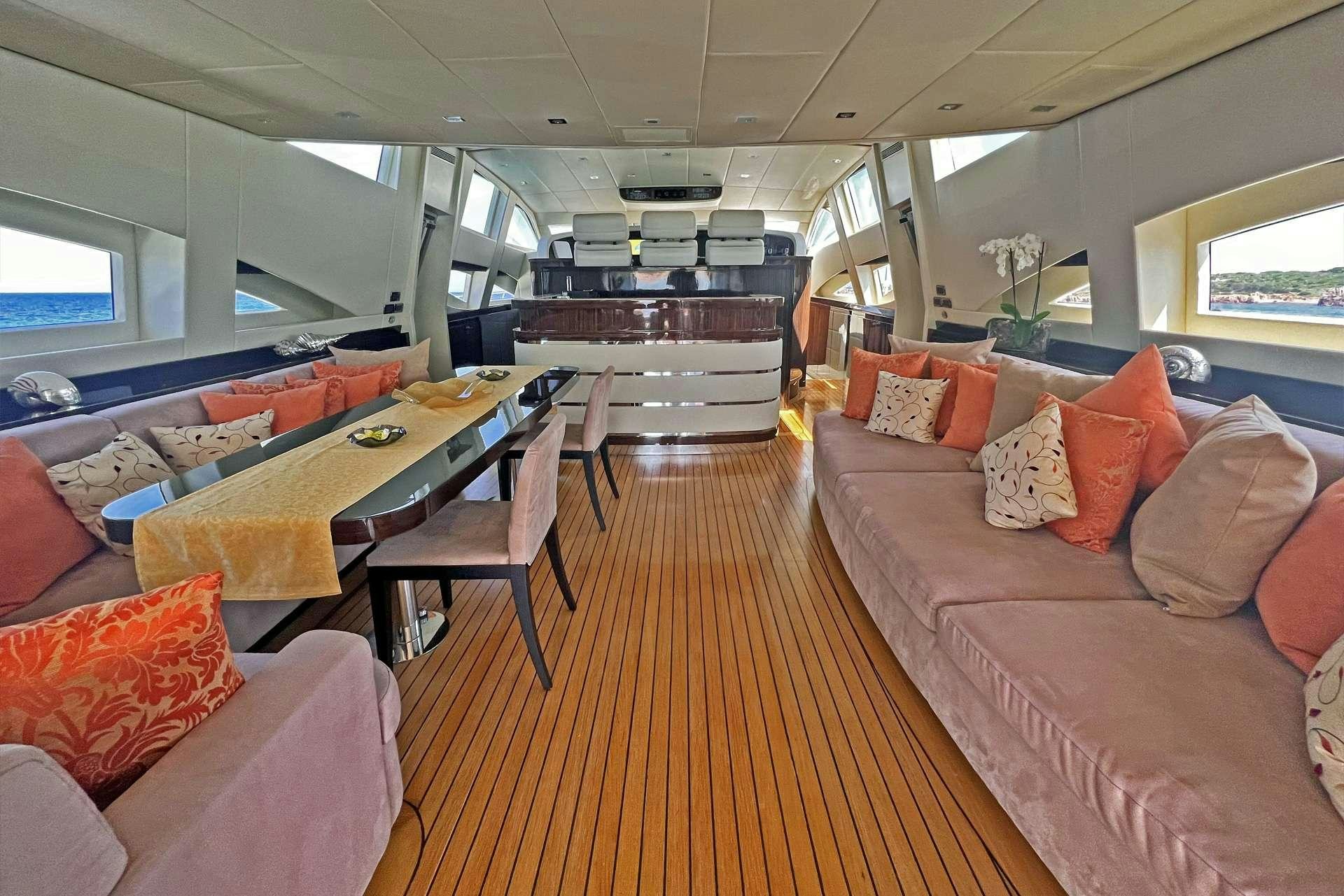 a train with a table and couches aboard ATHOS Yacht for Charter