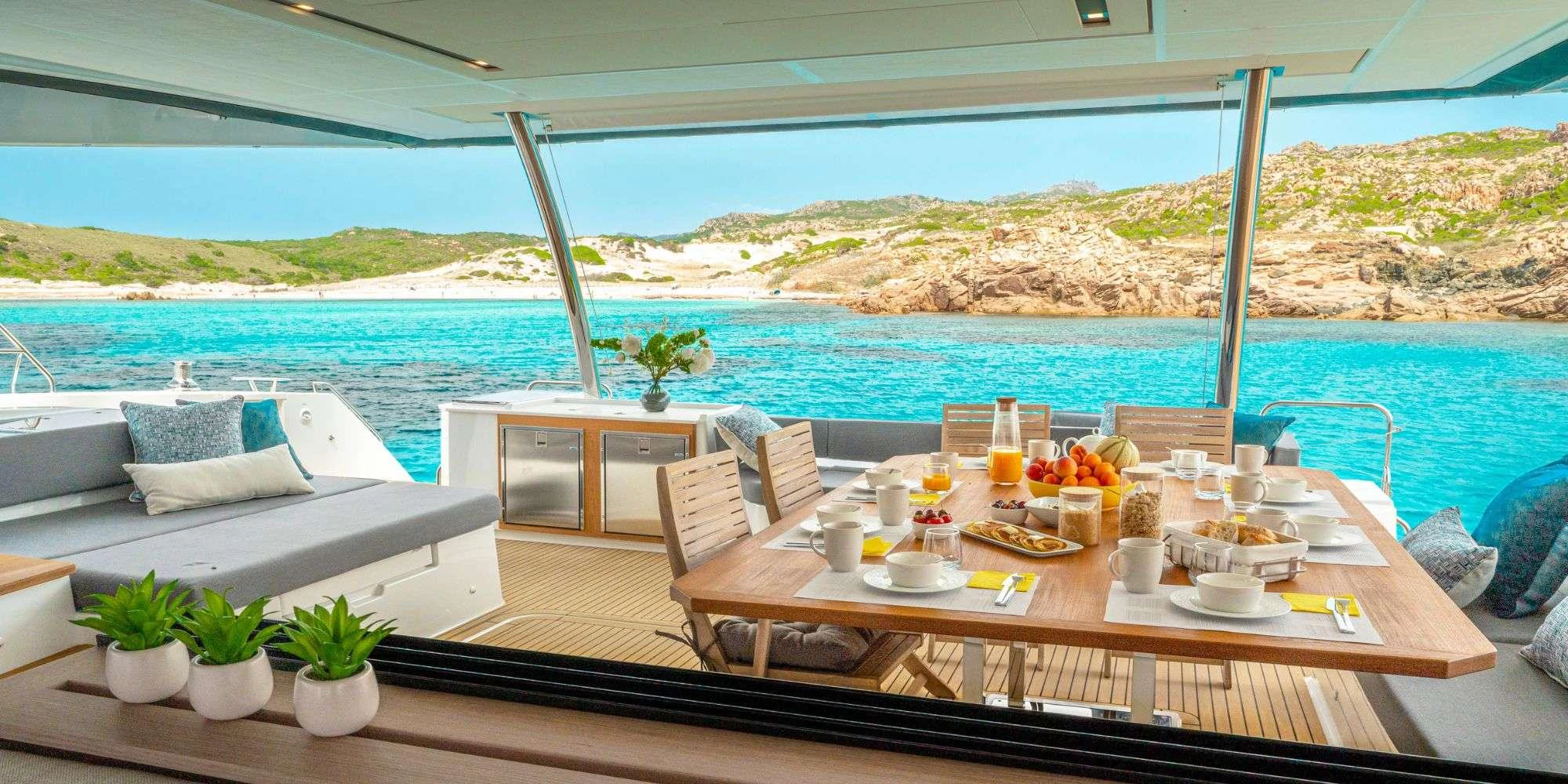a table with chairs and a view of the ocean aboard SEMPER FIDELIS Yacht for Charter