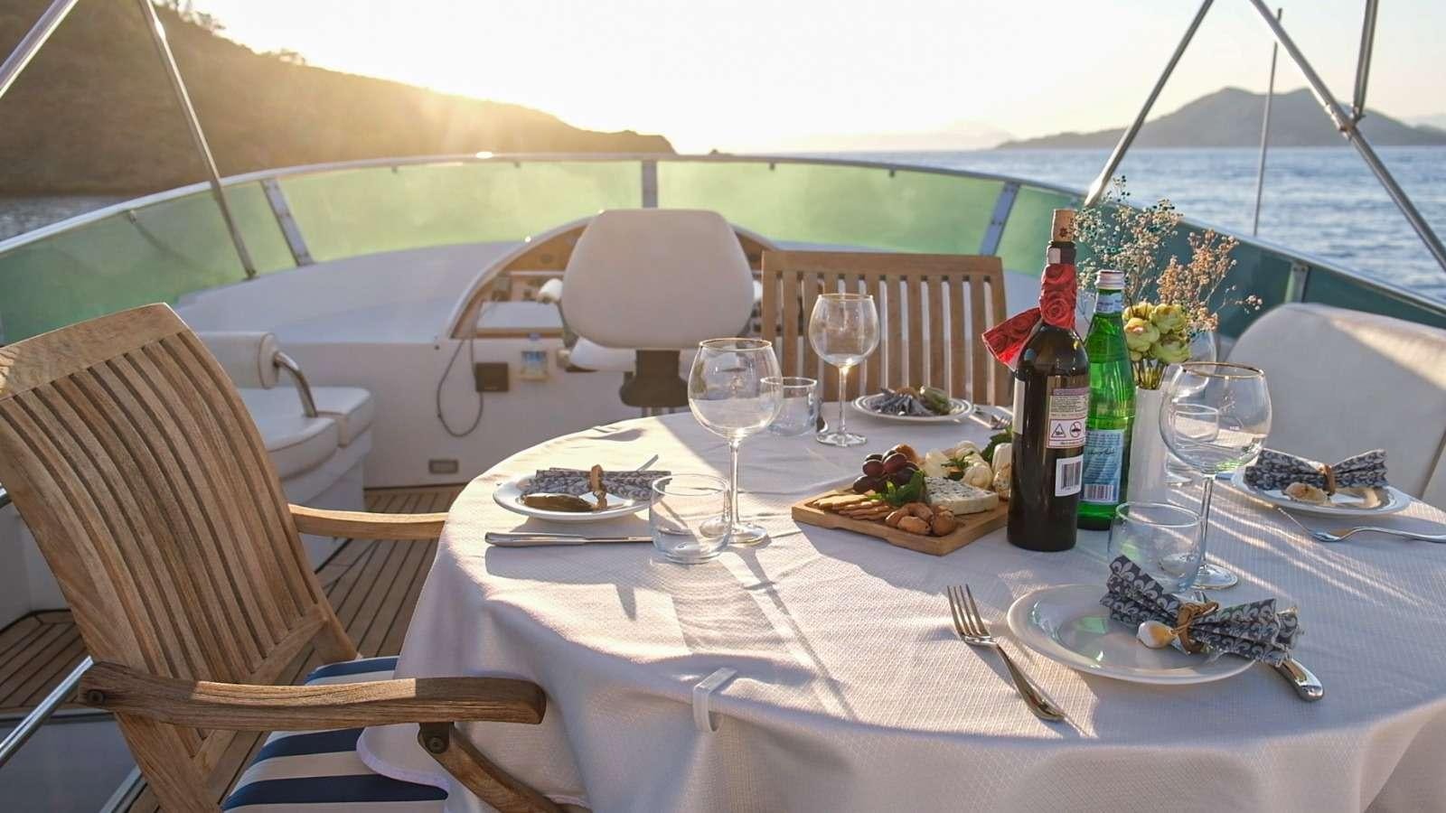 a table set with food and wine bottles on it aboard SIROCCO Yacht for Charter