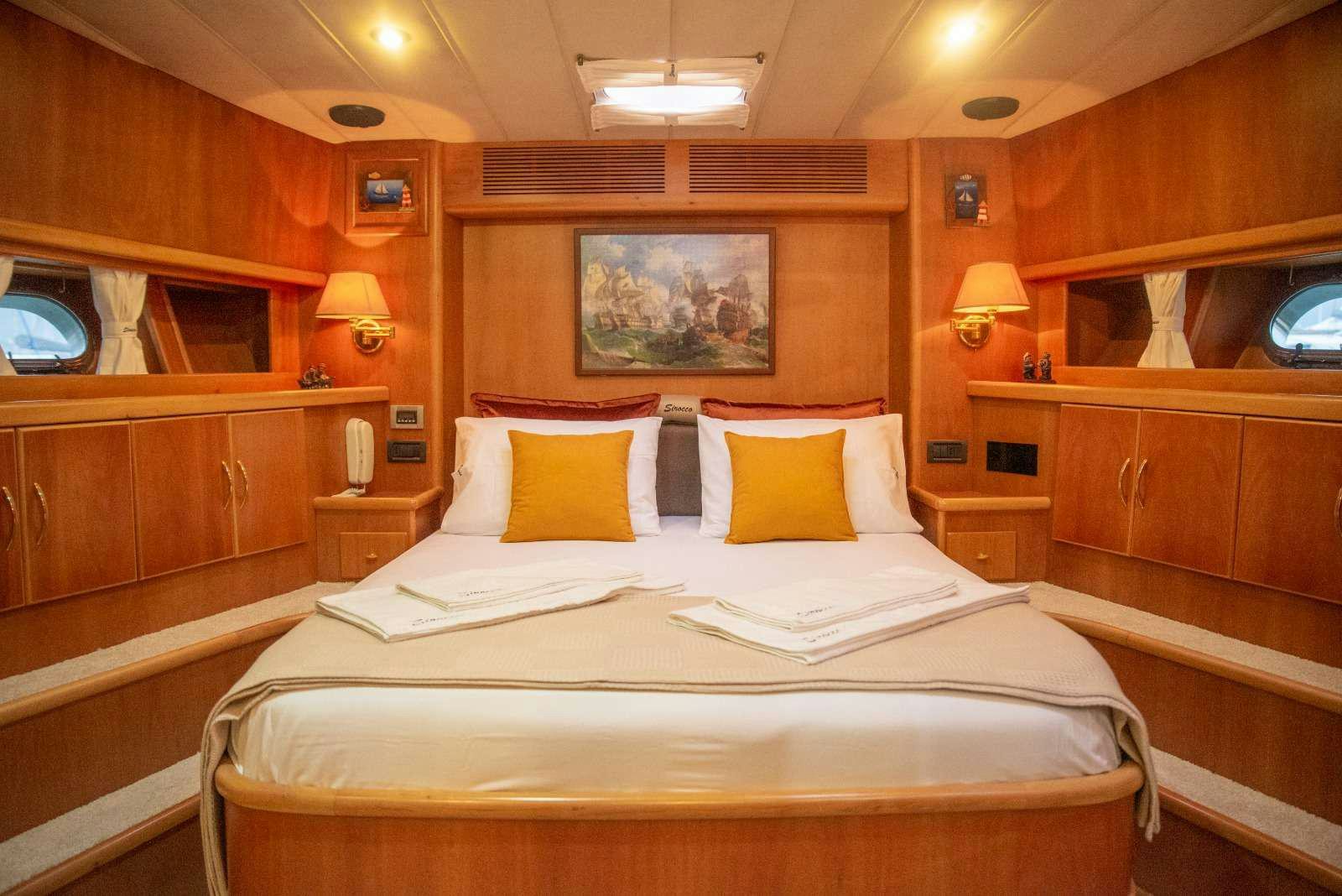 a room with a bed and a wood cabinet aboard SIROCCO Yacht for Charter