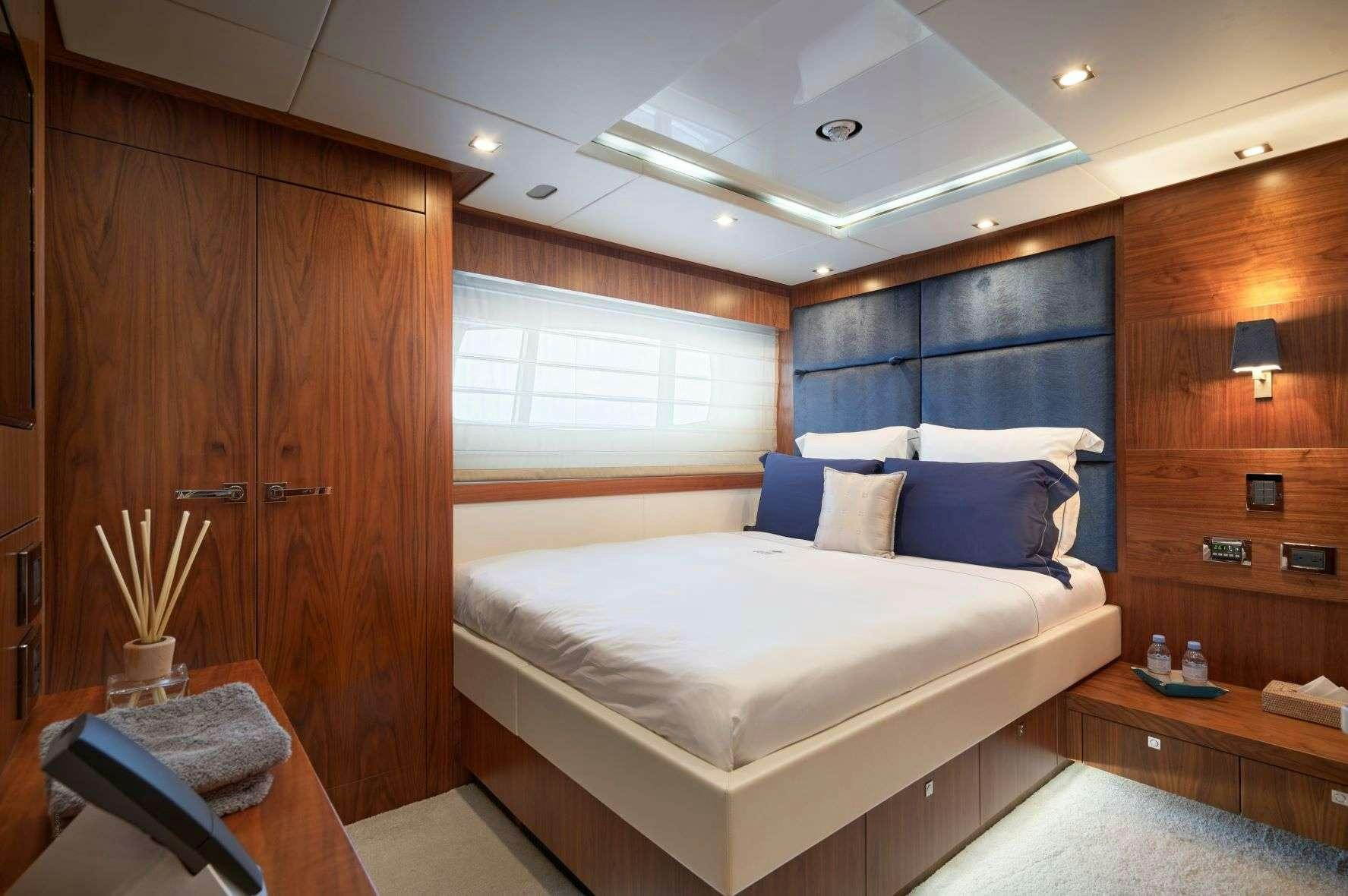 a room with a bed and a desk aboard EVEREAST Yacht for Charter