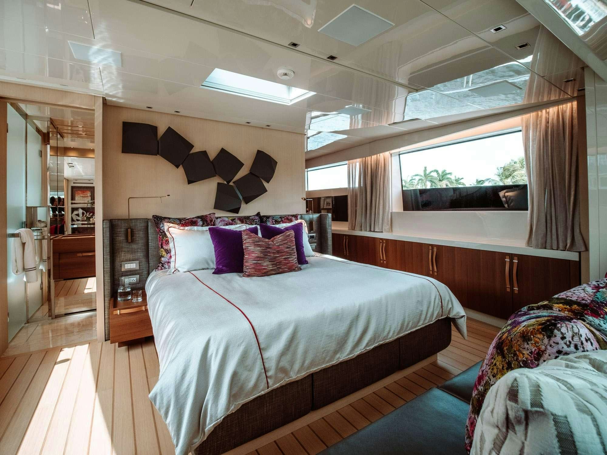 a bedroom with a bed and a window aboard FIFTY SHADES Yacht for Charter