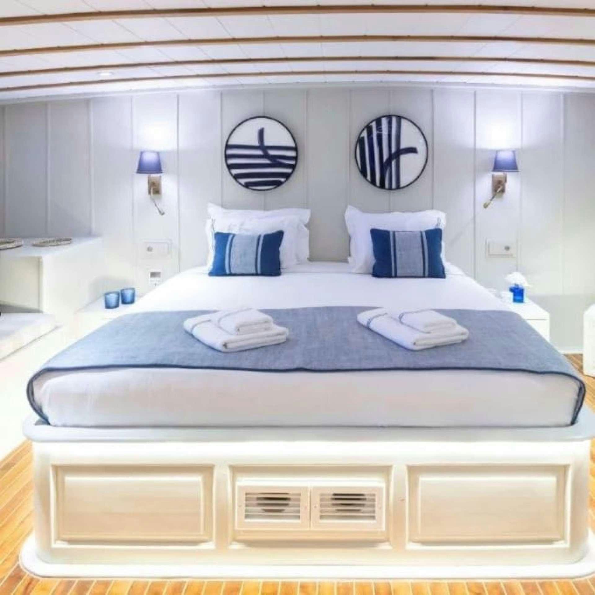 a bed with a blue comforter aboard CAUSTIC Yacht for Charter