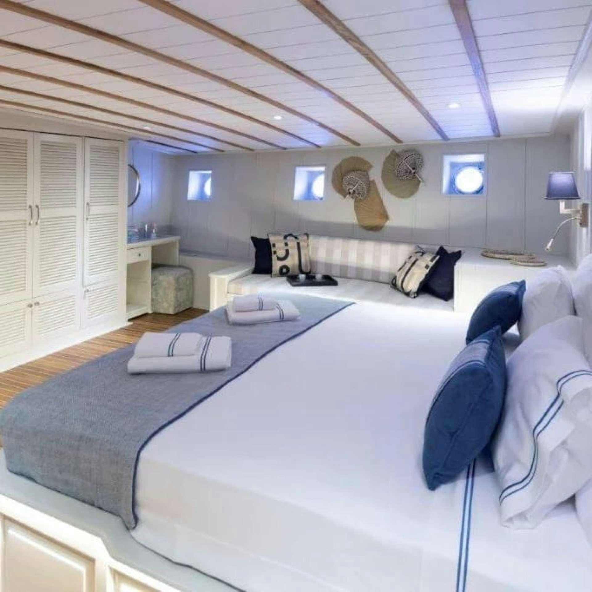 a room with a bed and a laptop on the bed aboard CAUSTIC Yacht for Charter