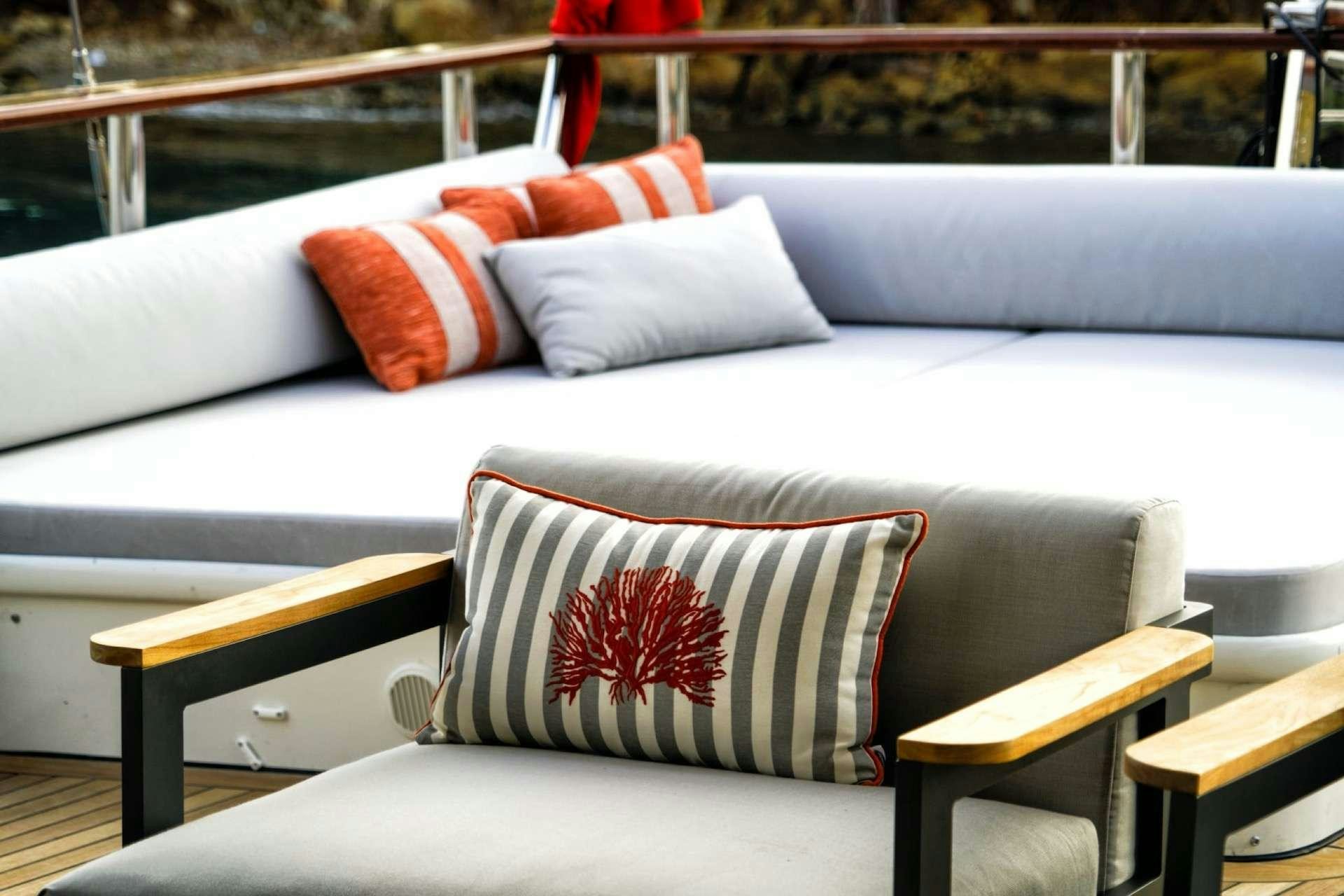a couch with pillows aboard CAUSTIC Yacht for Charter