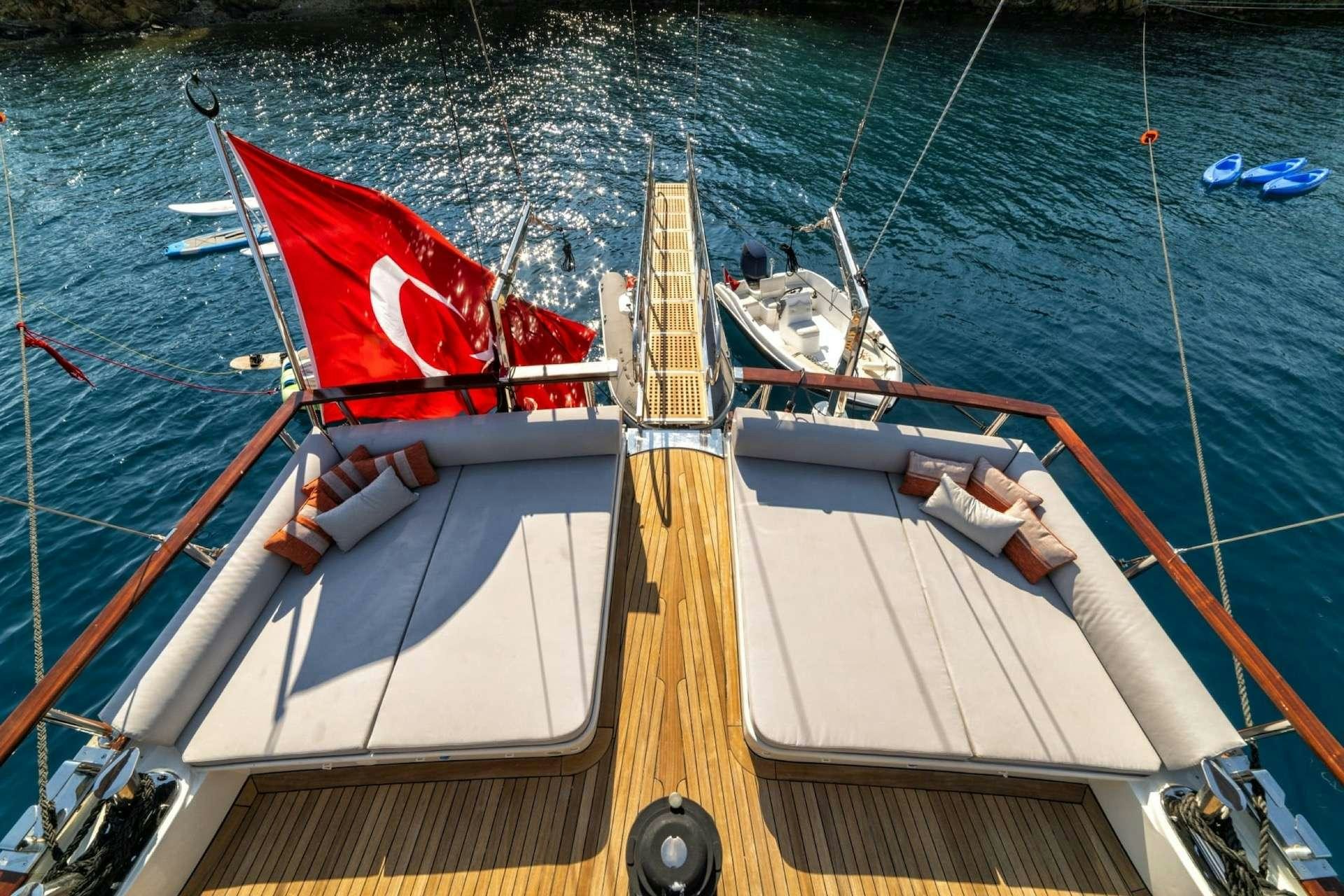a boat with a red sail aboard CAUSTIC Yacht for Charter