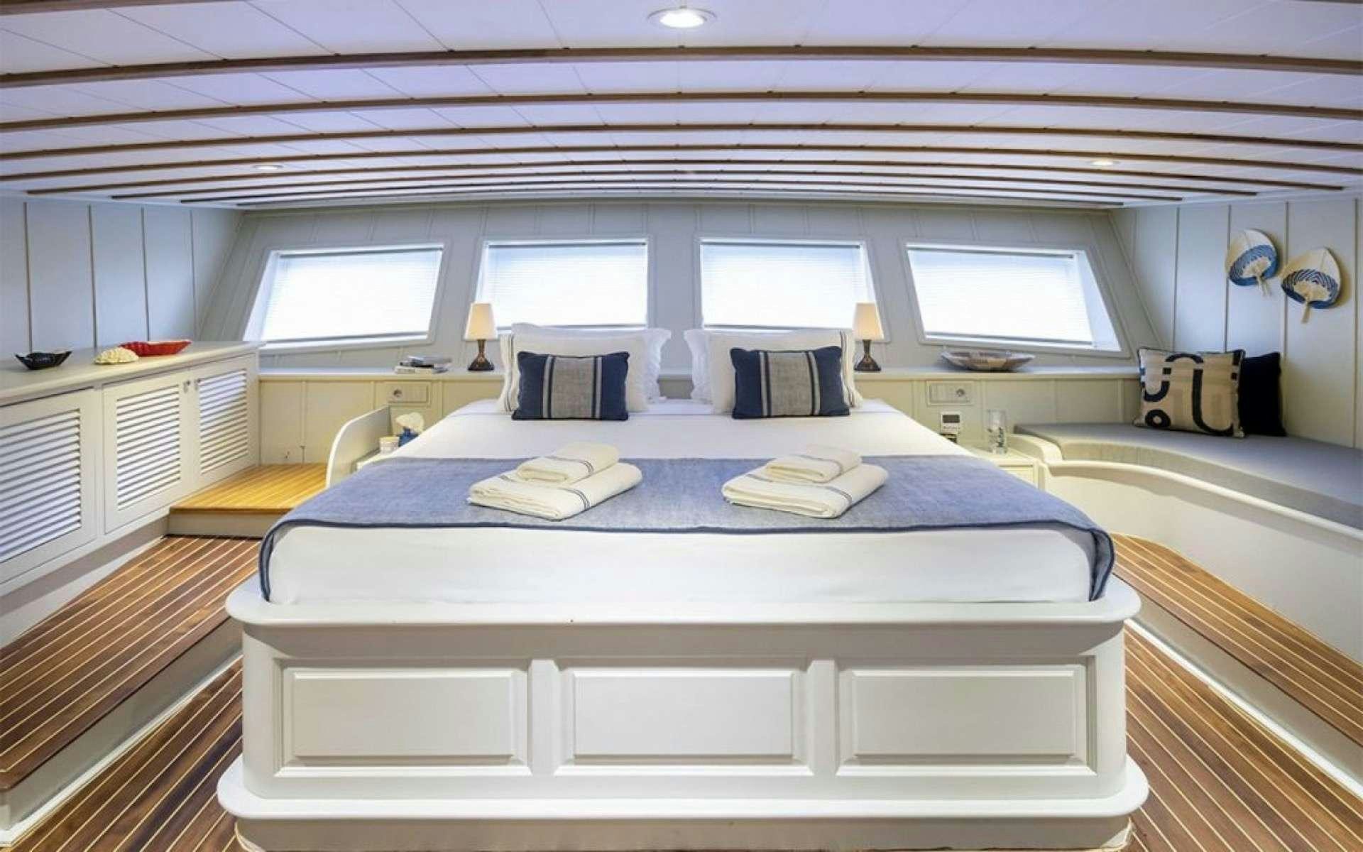 a room with a bed and a window aboard CAUSTIC Yacht for Charter