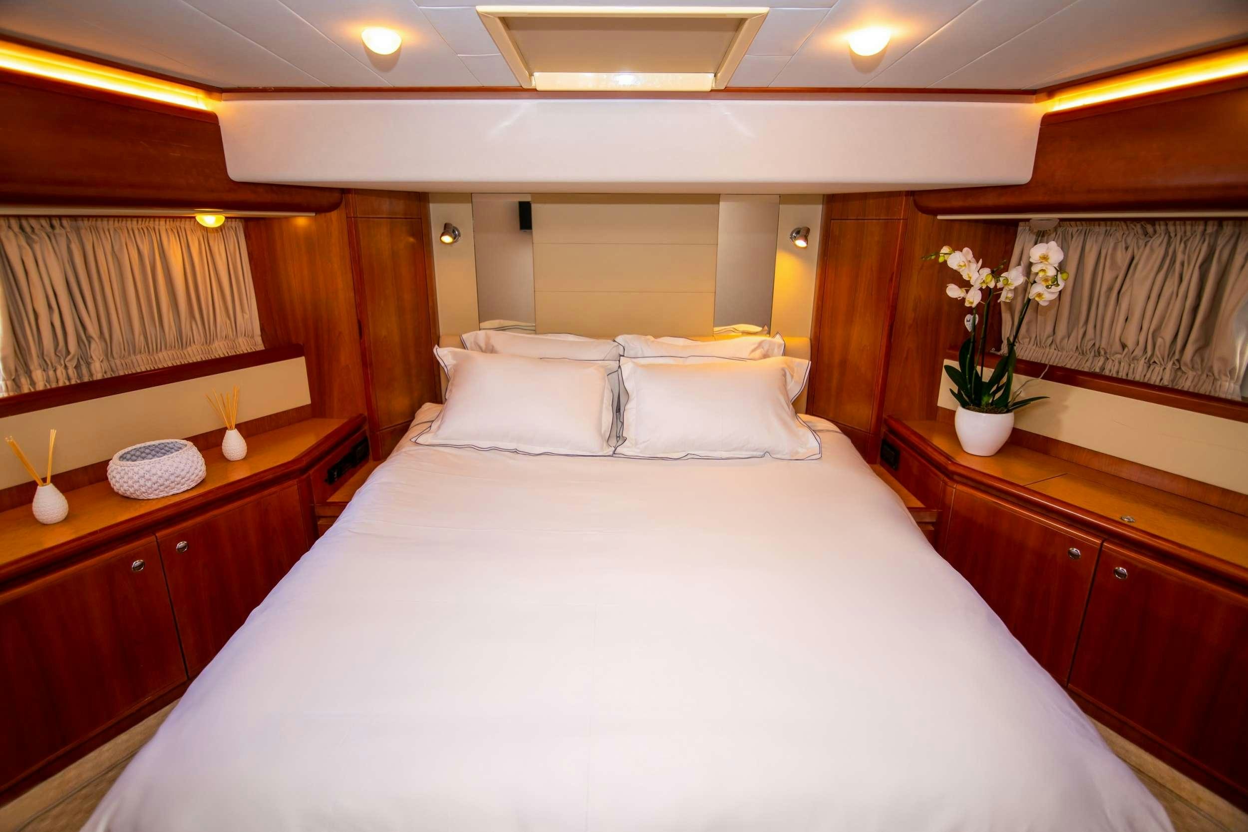 a bed with white sheets and pillows aboard SOFIA D Yacht for Charter