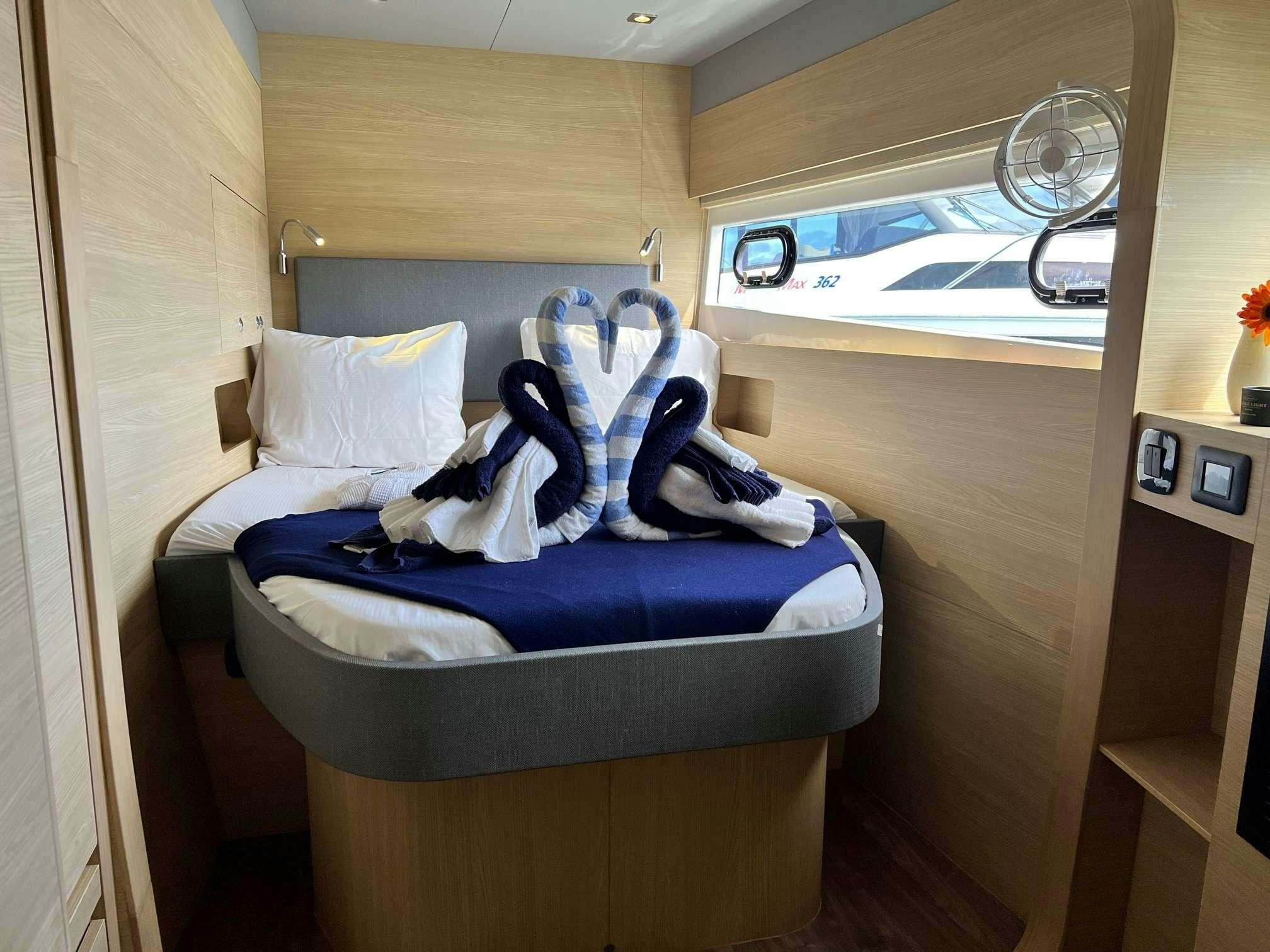 a bed with white sheets and shoes aboard GO TEAM Yacht for Charter