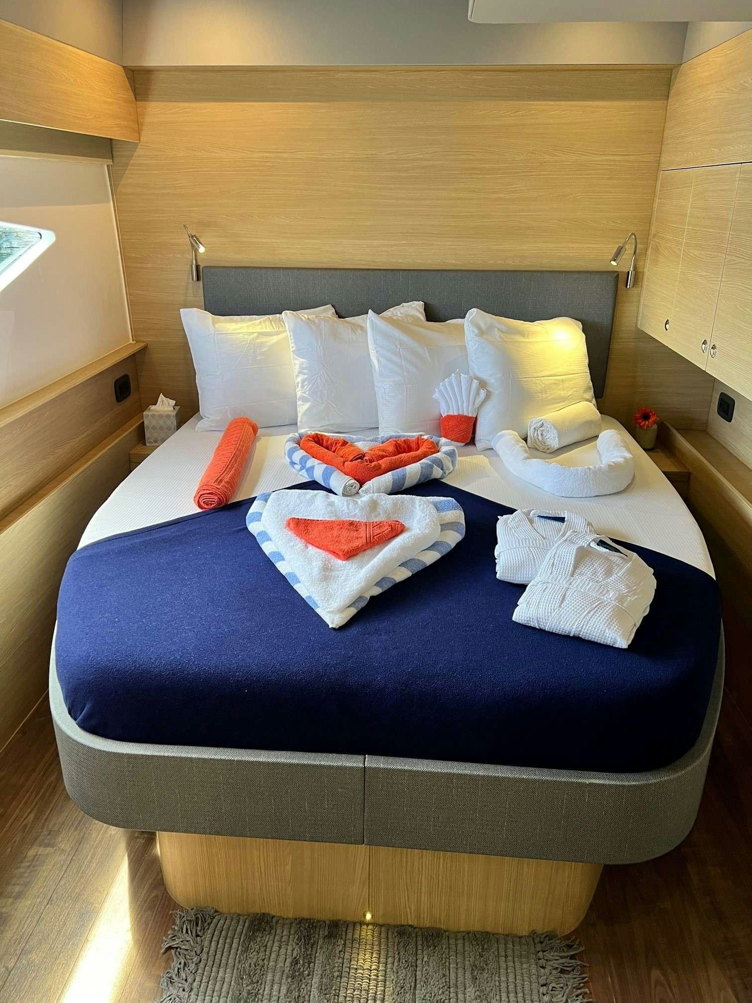 a bed with pillows and blankets aboard GO TEAM Yacht for Charter