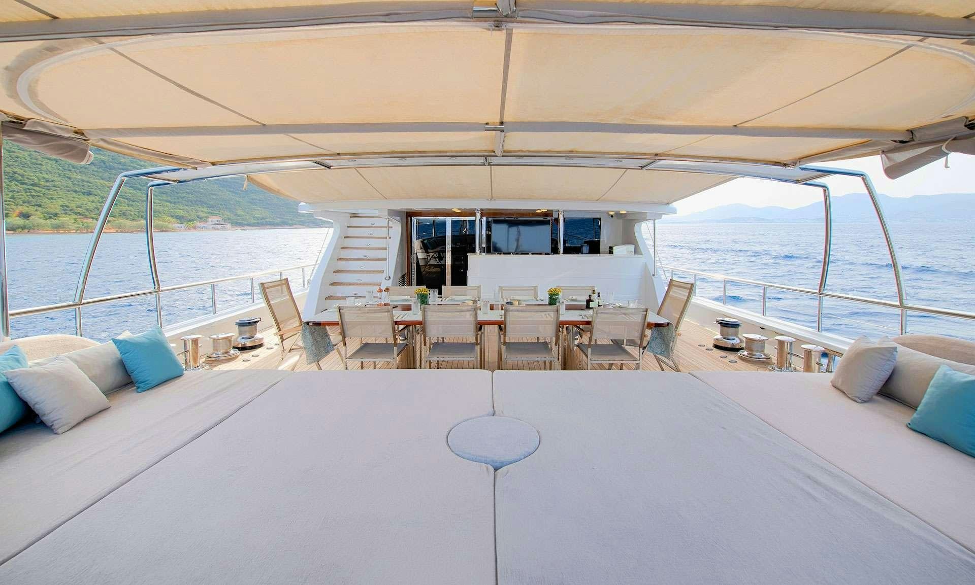 a large white lounge area with a large white lounge chair and a large body of water aboard THE WALL Yacht for Charter