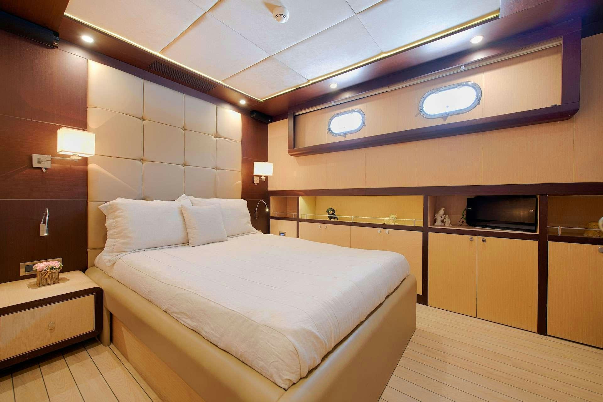 a room with a bed and a television aboard THE WALL Yacht for Charter