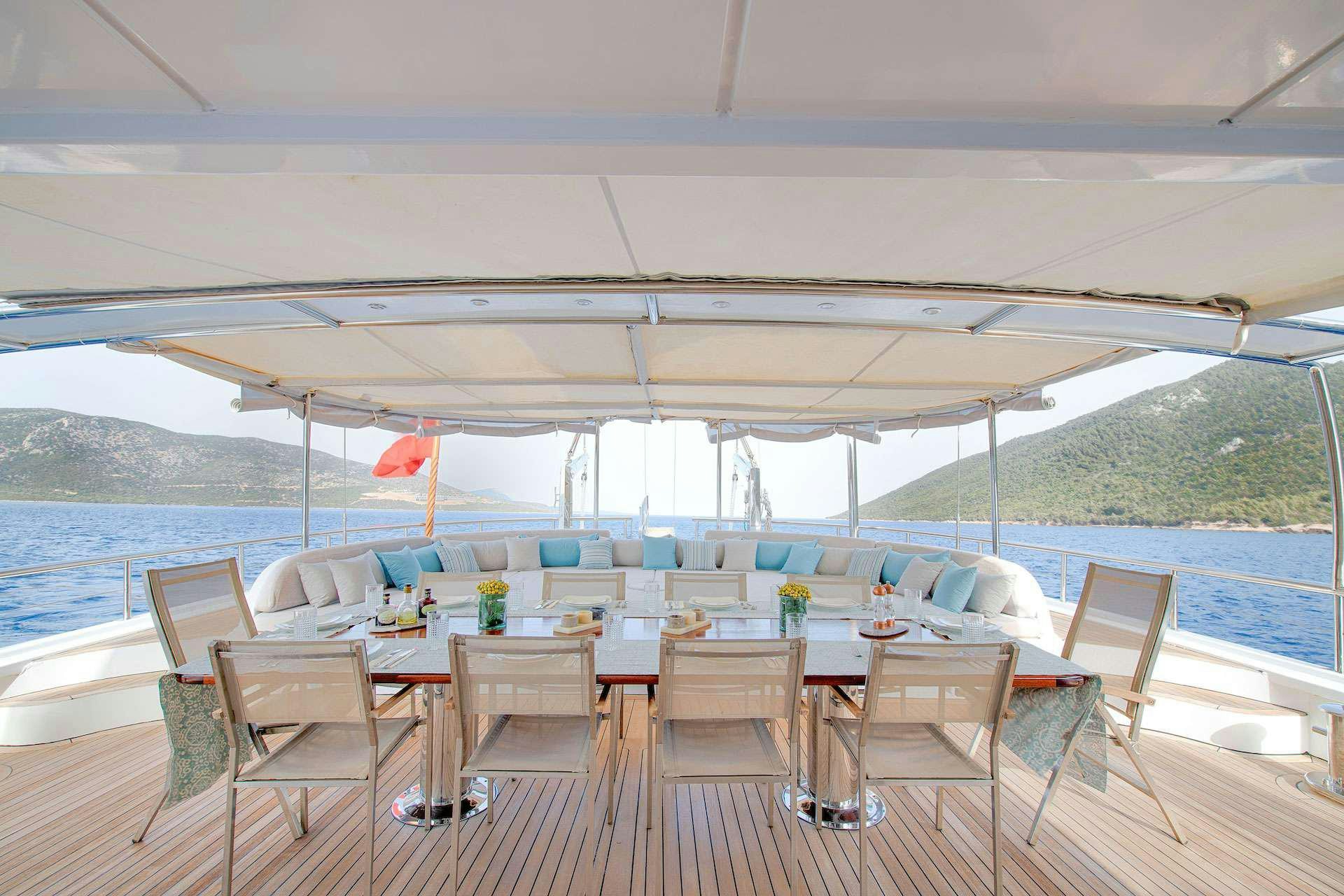 a large white tent with chairs and tables and a pool aboard THE WALL Yacht for Charter