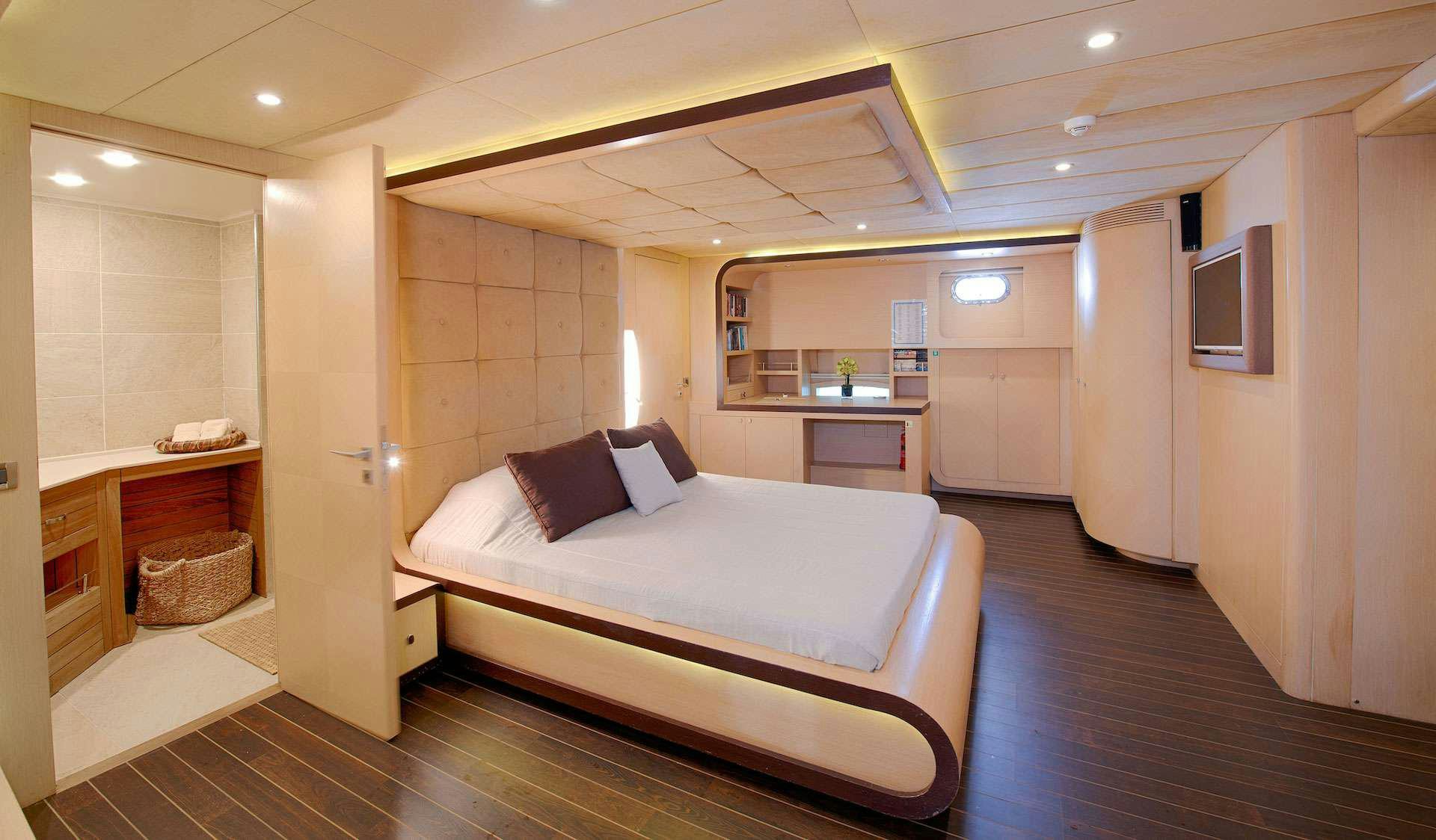 a room with a bed and a desk aboard THE WALL Yacht for Charter