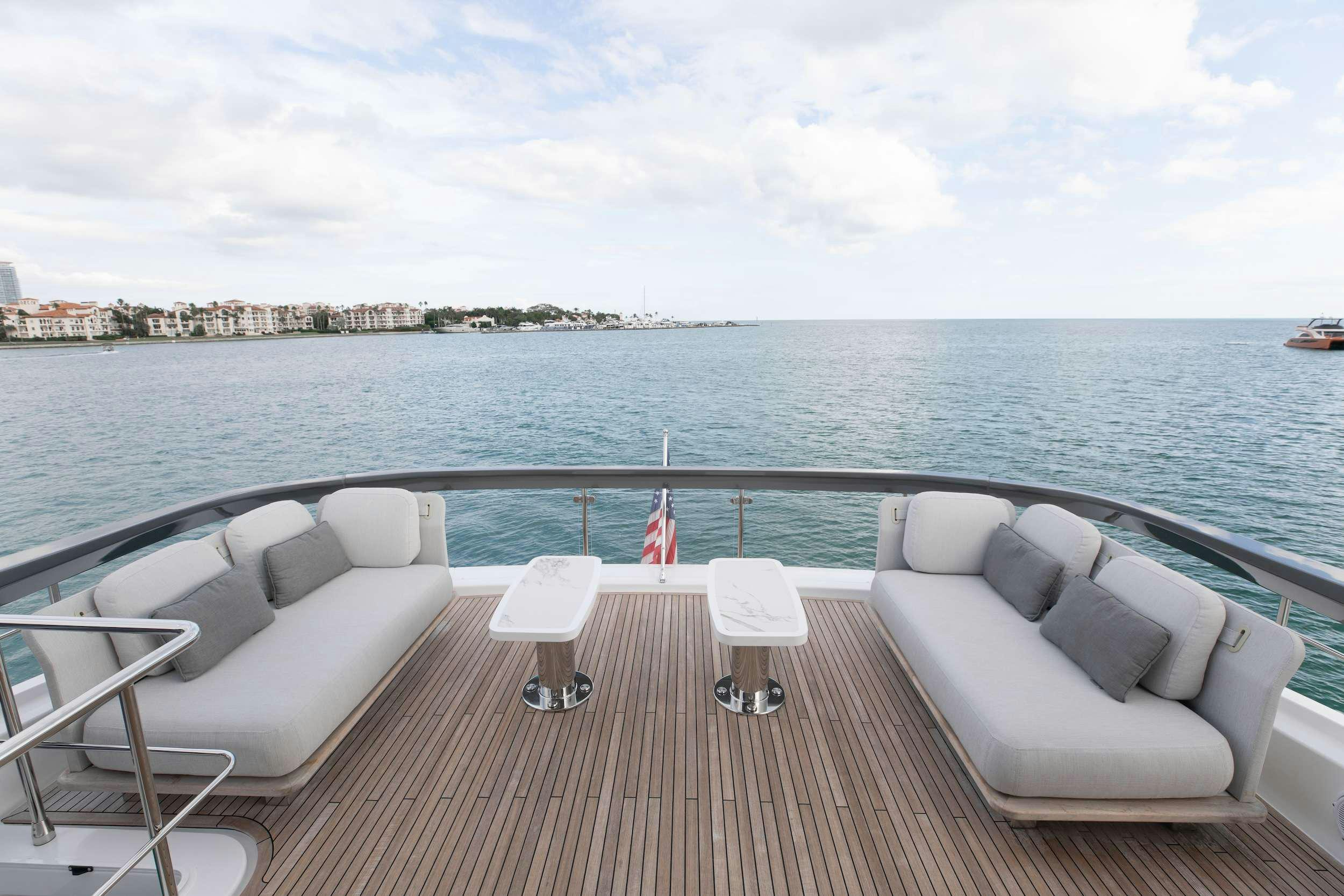 a deck with chairs and a body of water in the background aboard NENA Yacht for Charter