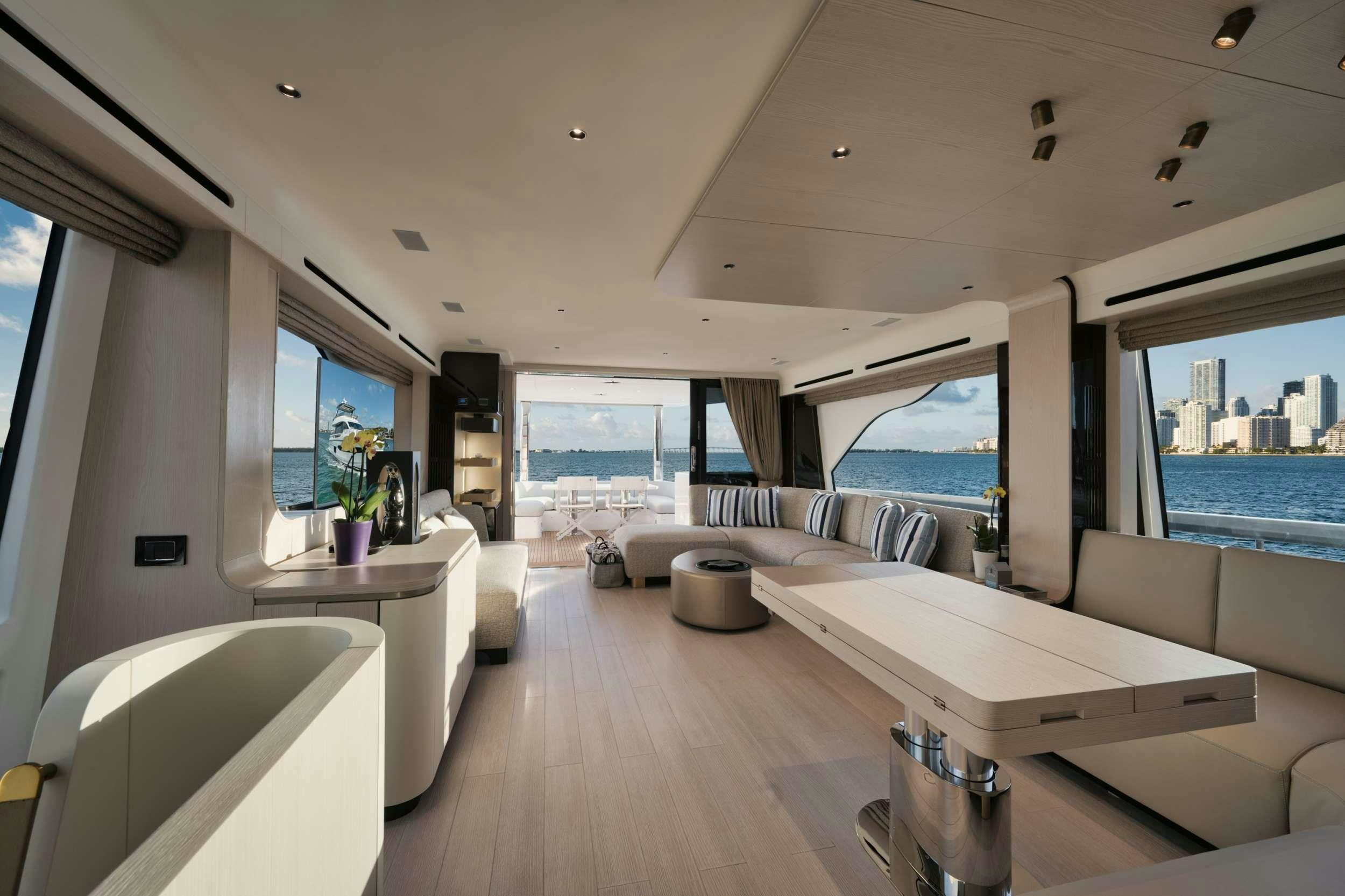 a room with a large window and a table with chairs and a large window aboard NENA Yacht for Charter
