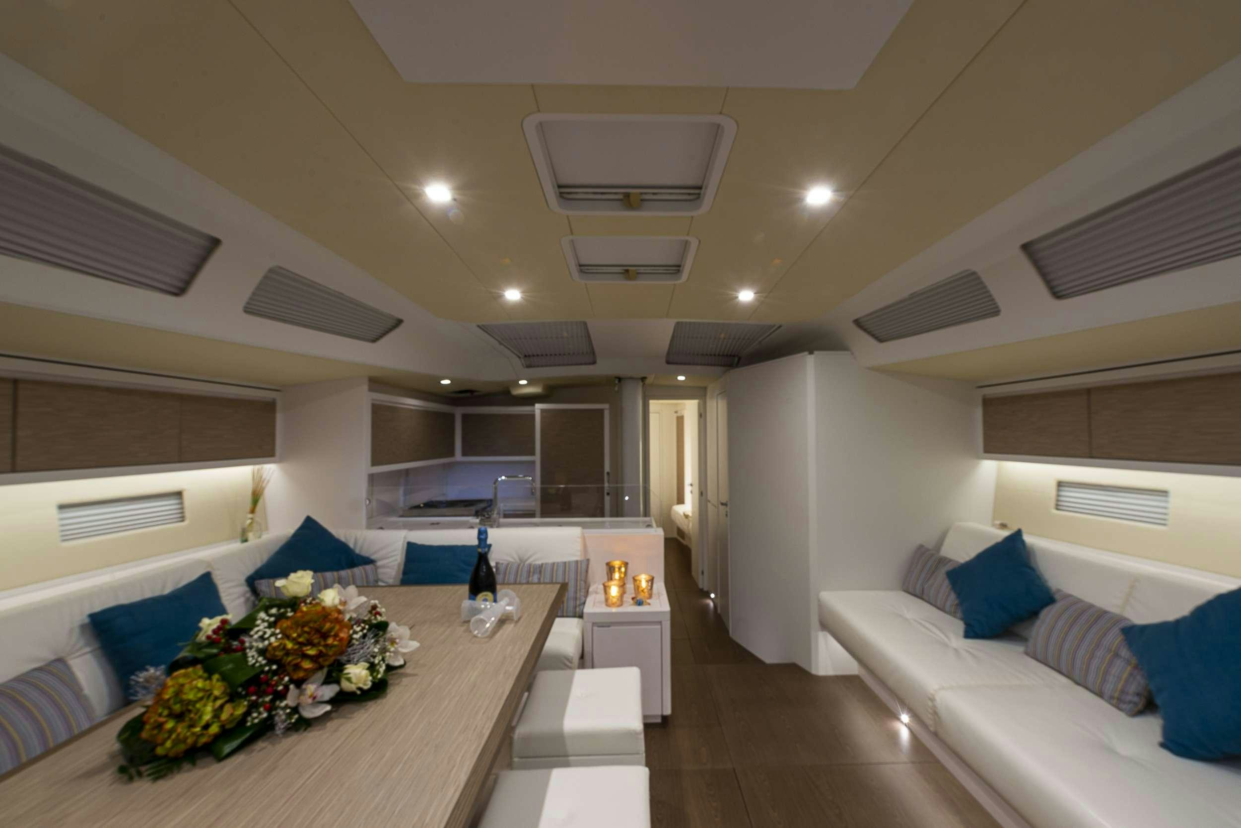 a room with a table and couch aboard PURA FOLLIA Yacht for Charter