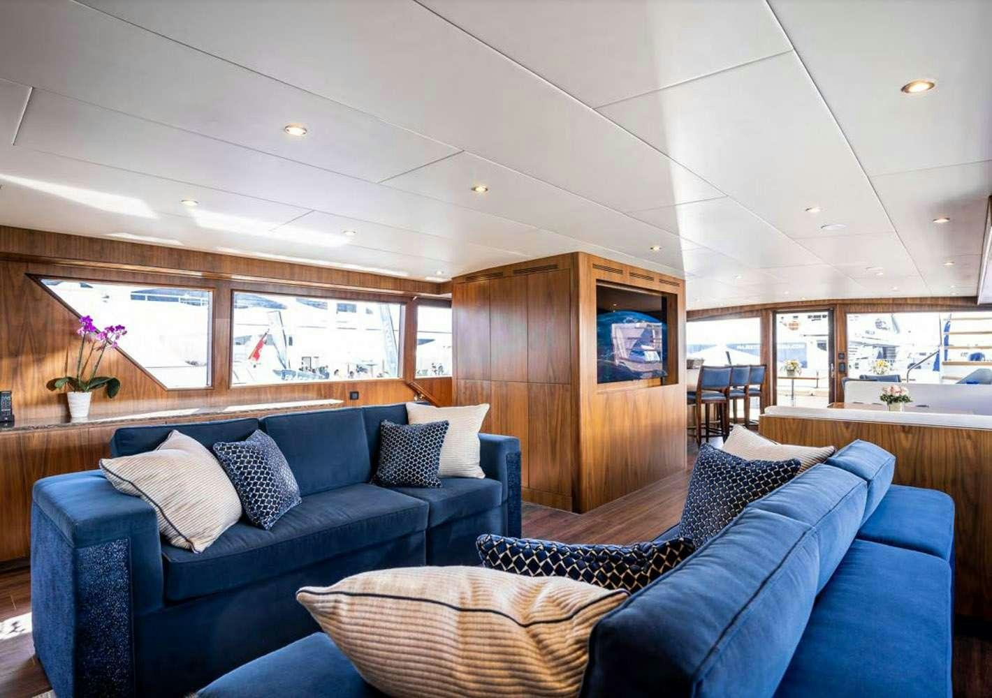 a living room with a blue couch aboard A PLACE IN THE SUN Yacht for Charter