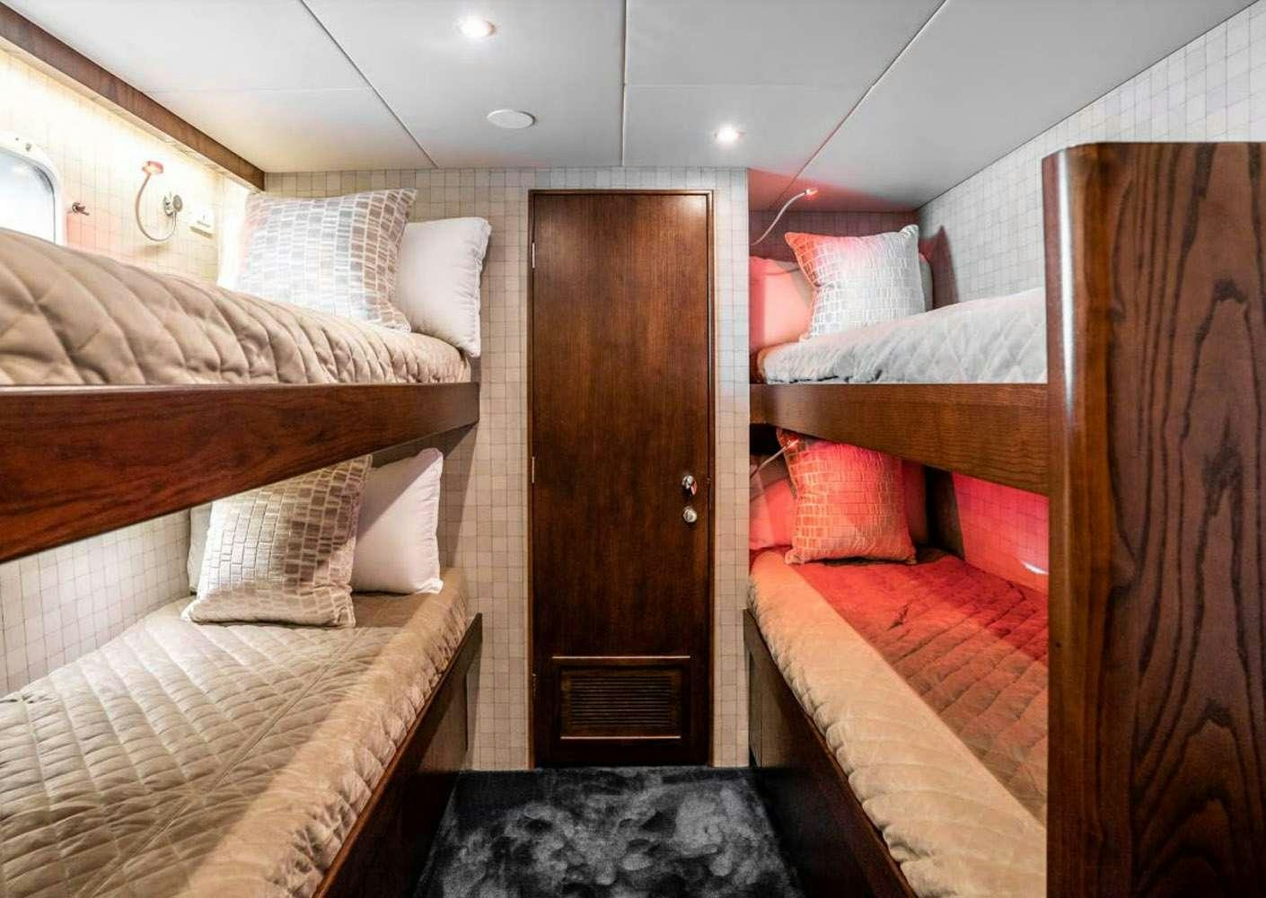 a room with a bed and a door aboard A PLACE IN THE SUN Yacht for Charter