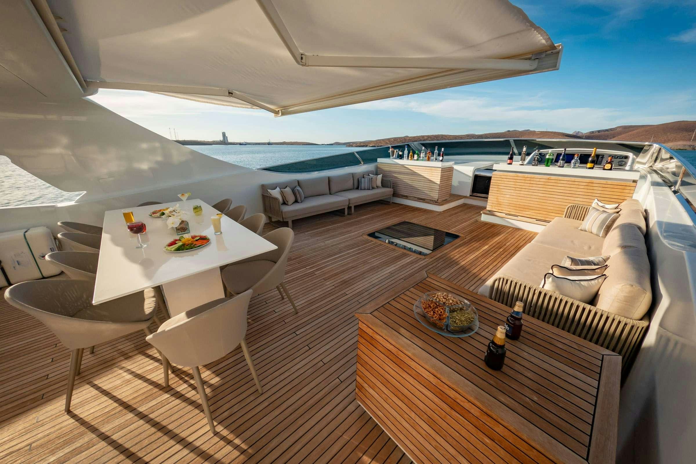 a large lounge area with a table and chairs on it aboard CADA UNO  Yacht for Charter
