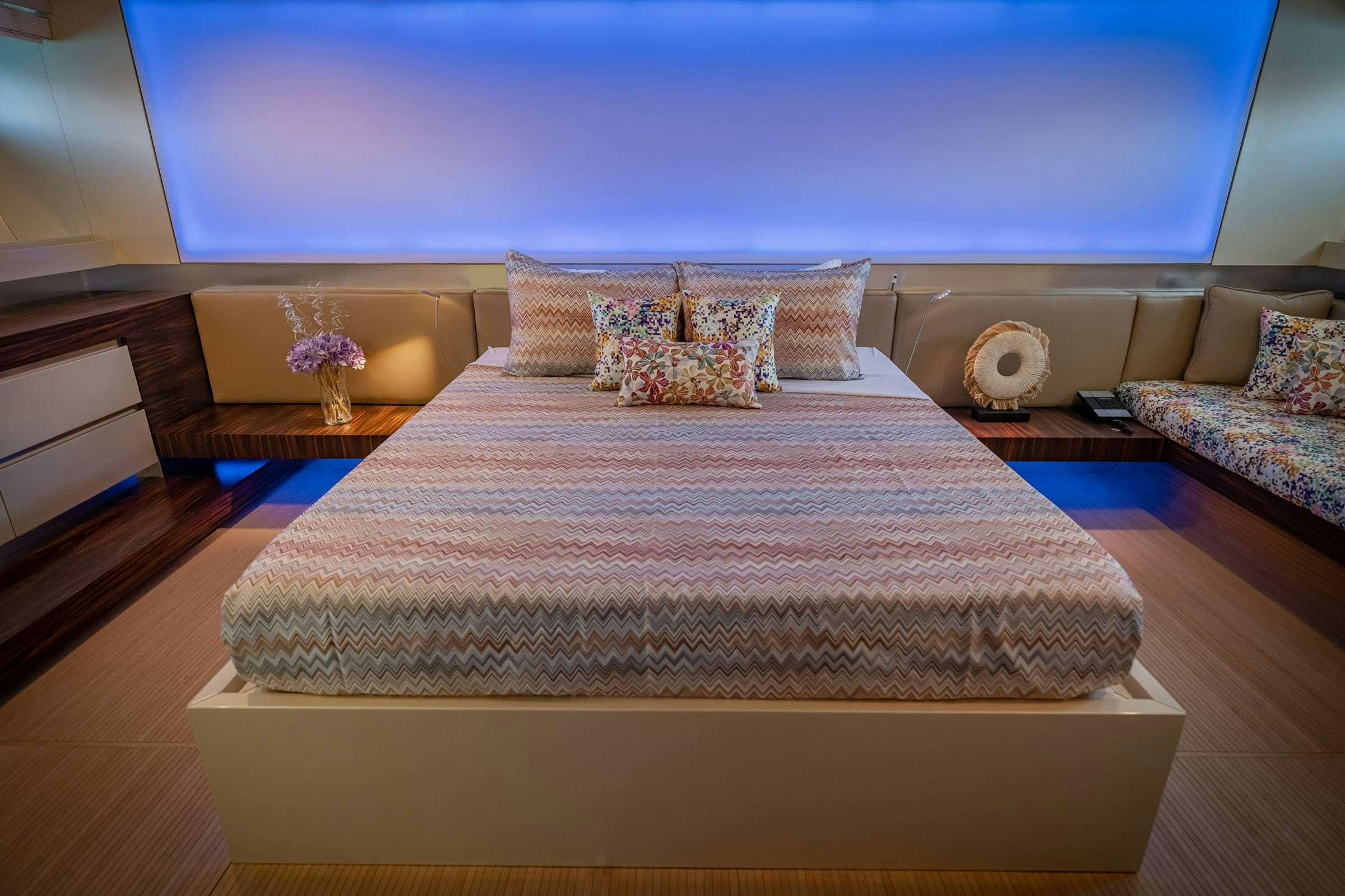 a bed with a purple comforter aboard CADA UNO  Yacht for Charter