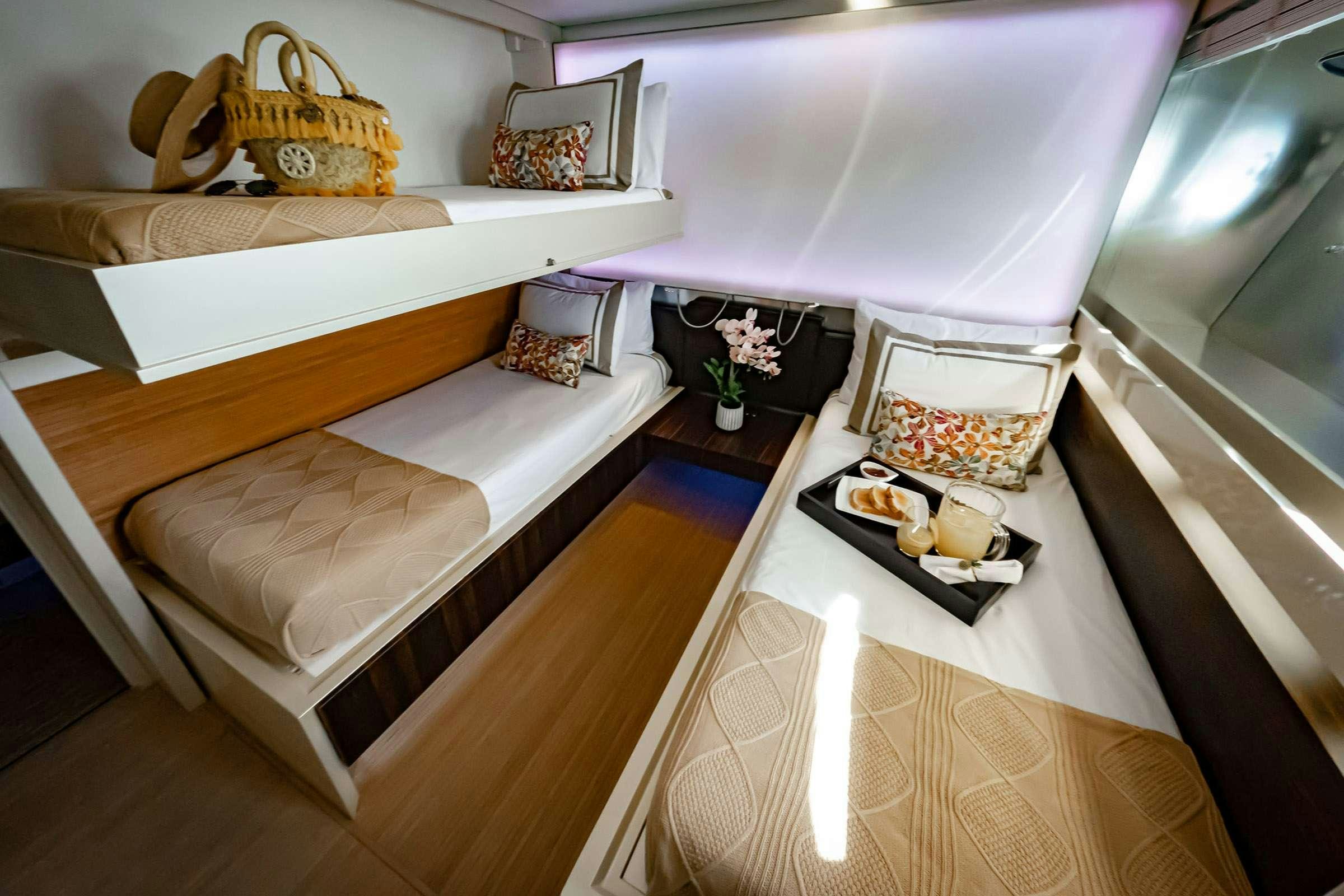 a bed with a white sheet and a basket with candles on it aboard CADA UNO  Yacht for Charter