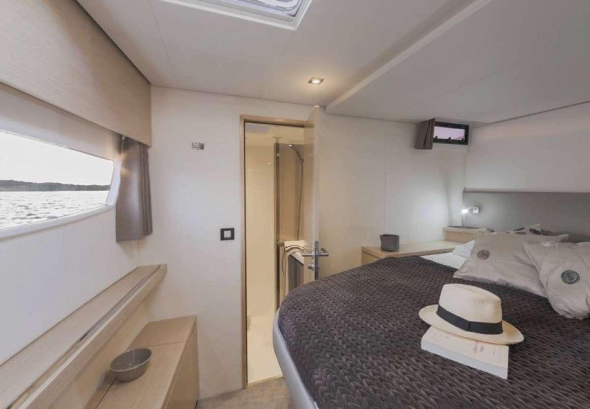 a bedroom with a bed and a desk aboard Daydreams Yacht for Charter