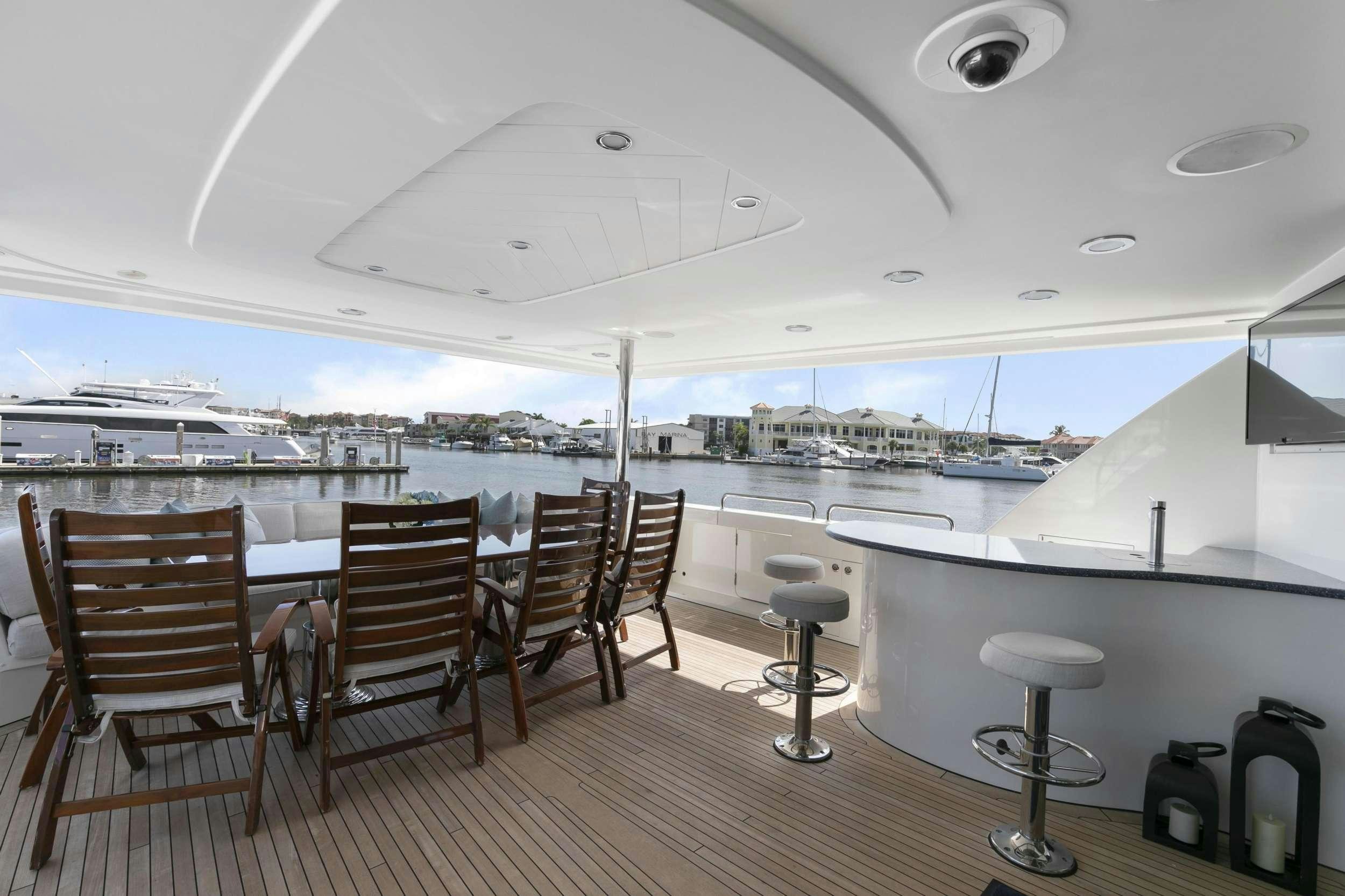 a room with a table chairs and a view of the city aboard EDEN Yacht for Charter