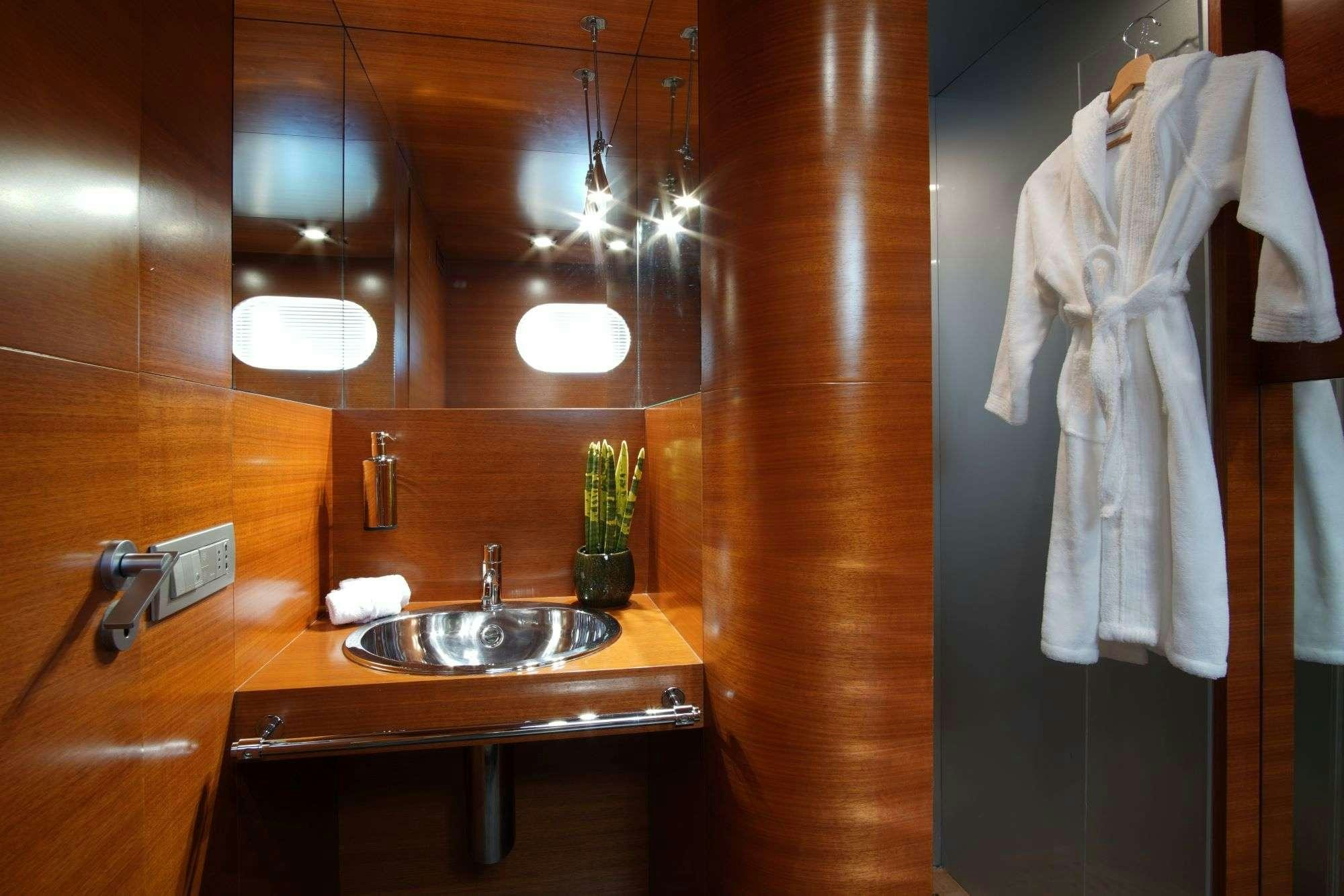 a bathroom with a sink and a towel from the ceiling aboard SATORI Yacht for Charter
