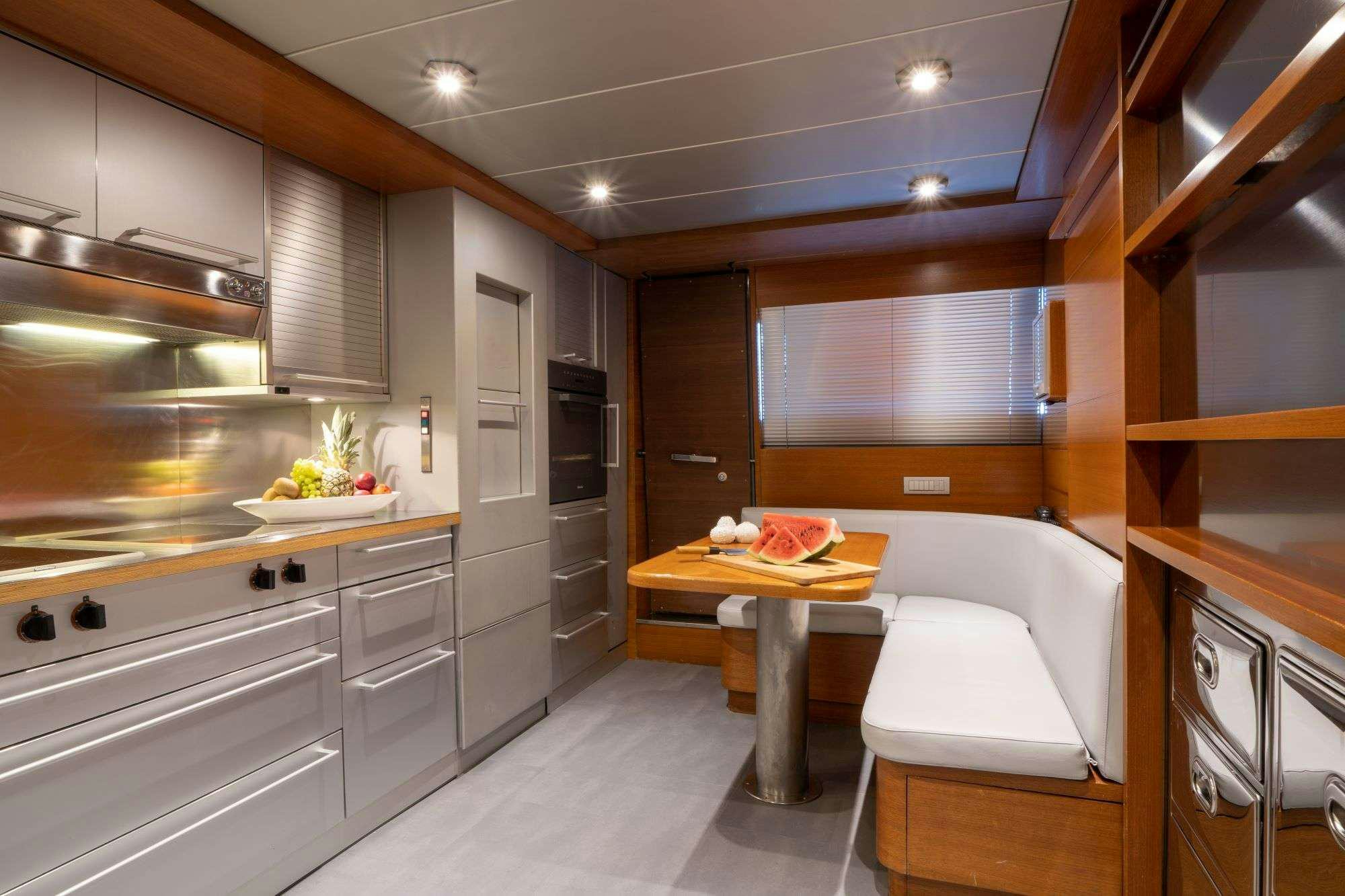 a kitchen with a table and a bed aboard SATORI Yacht for Charter