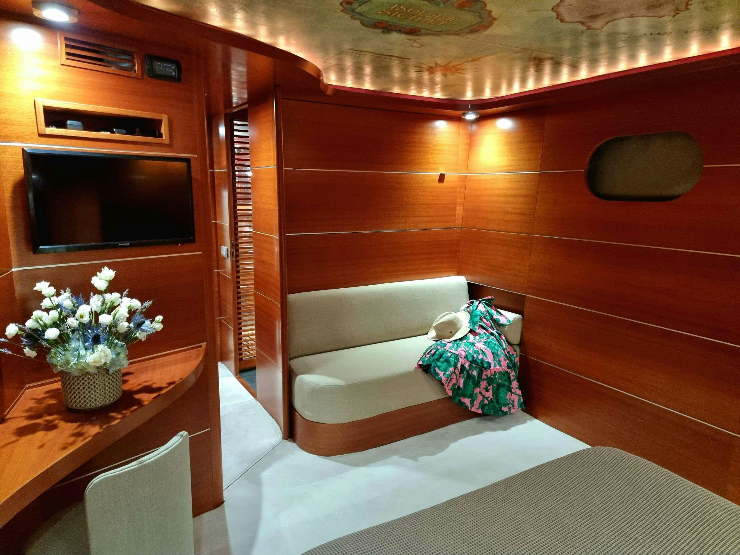 a room with a bed and a television aboard SATORI Yacht for Charter