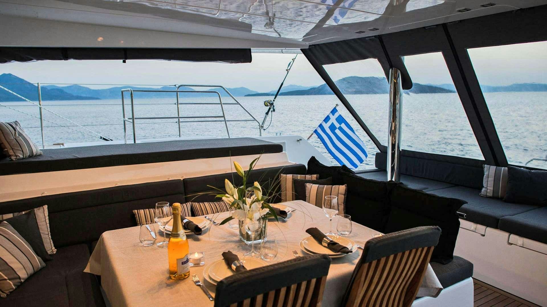 a table with glasses and a vase with flowers on it aboard Alyssa Yacht for Charter