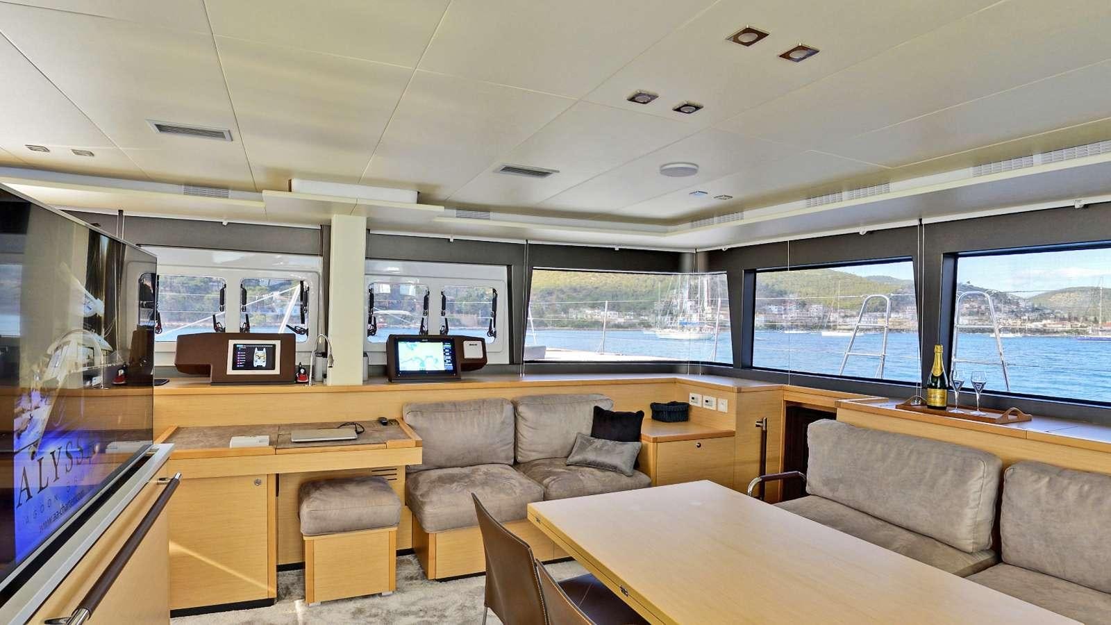 a room with a couch and a table and a tv aboard Alyssa Yacht for Charter