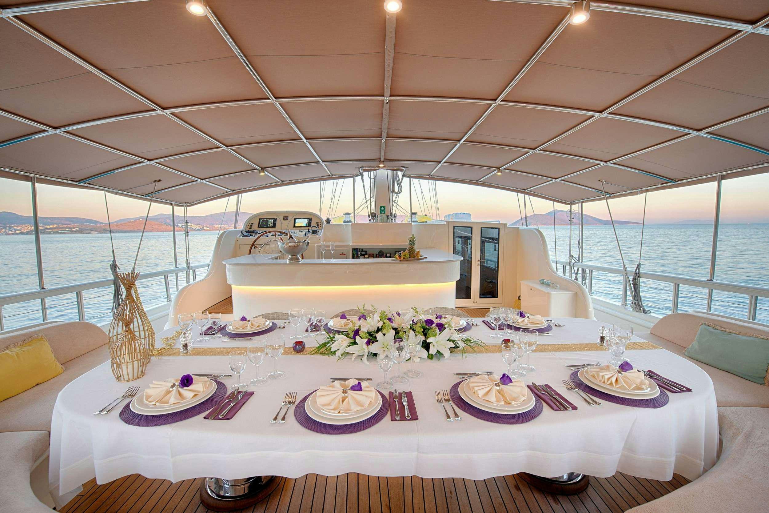 a table set for a dinner aboard QUEEN OF SALMAKIS Yacht for Charter